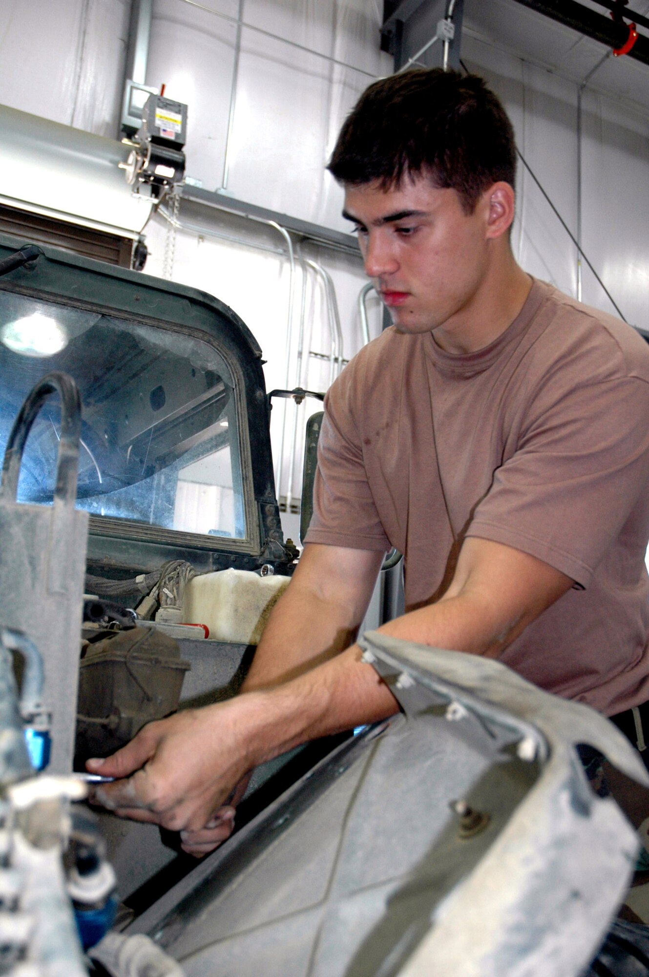Senior Airman Kevin Roberts, auto mechanic from the 305th Logistics Readiness Squadron working for the U.S. Air Force Expeditionary Center's Expeditionary Operations School vehicle maintenance shop, works on repairs for a HMMWV Sept. 12 at Fort Dix, N.J.  Airman Roberts is one of a few mechanics who maintains a fleet of vehicles that includes HMMWVs, military trucks, forklifts, four-wheeler all terrain vehicles, and standard trucks, cars and vans for Expeditionary Center use.  (U.S. Air Force Photo/Tech. Sgt. Scott T. Sturkol)