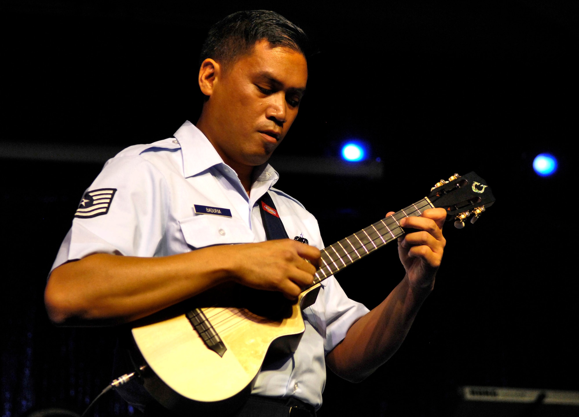 Tech. Sgt. Daniel Baduria plays his ukulele as the opening act for Tops In Blue Sept. 12 at the Waikiki Shell in Honolulu. Sergeant Baduria played as part of the Heritage to Horizons theme of the Air Force's 60th anniversary. His father, Donald Baduria, was an Airman with the Strolling Strings Trio in the Air Force's Tops In Blue entertainment showcase in the 1950s and began teaching him to play the ukulele at age four. Sergeant Baduria, who lost his father to cancer more than 20 years ago, honored his memory during the performance. Tops In Blue, the Air Force's signature entertainment group, gave a free performance for the public to celebrate Air Force Week Honolulu and the Air Force's 60th anniversary. Sergeant Baduria, is an aircraft fuel systems specialist with the Hawaii Air National Guard's 154th Wing. (U.S. Air Force photo/Tech. Sgt. Shane A. Cuomo)