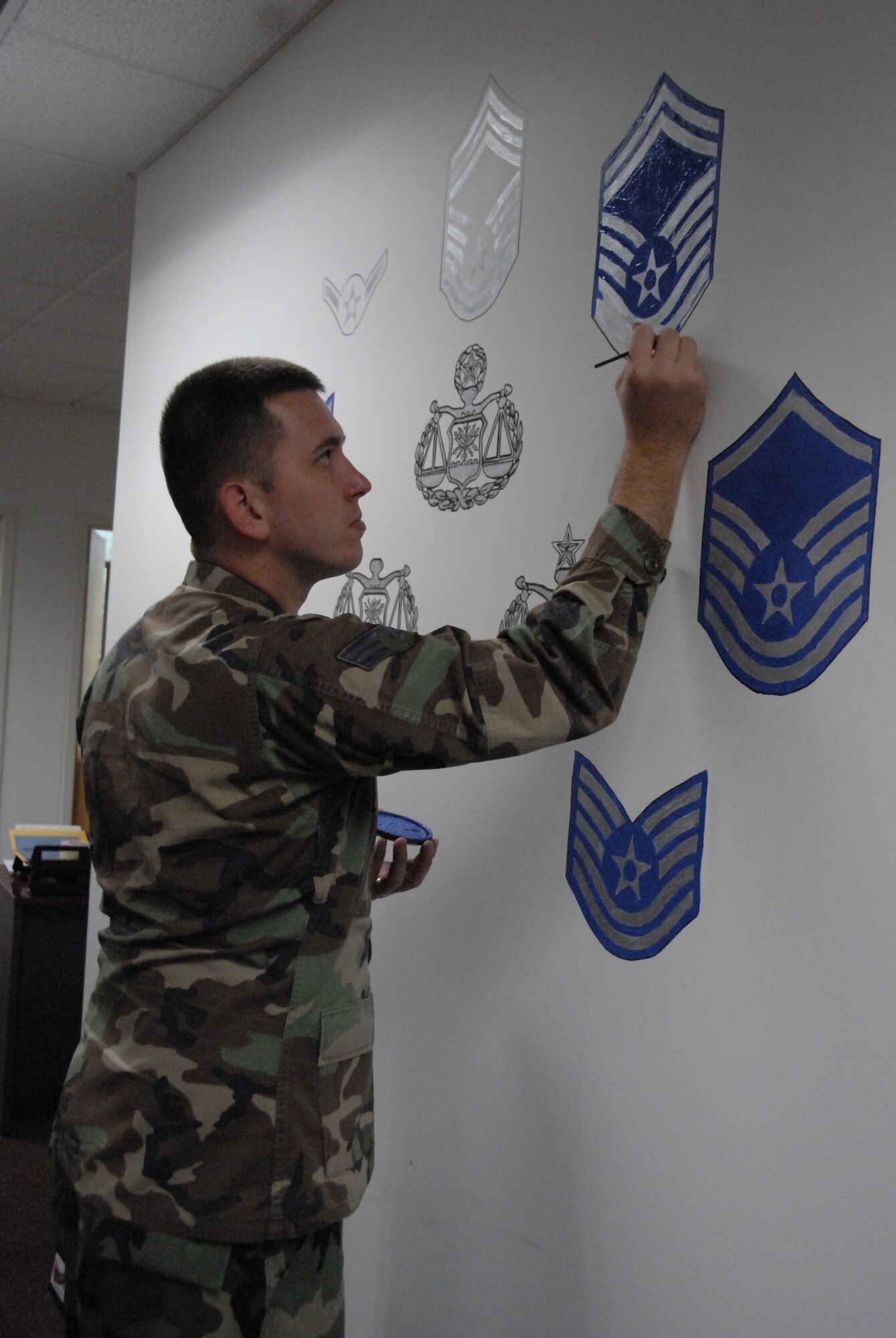 Hanscom Air Force Base, Mass. -- Senior Airman Timothy Galloway, 66th Air Base Wing Judge Advocate Office, adds the finishing touches to a beautification project in the lobby of the Legal Office Sept. 10. 
“So many people automatically think of attorney or ‘JAG’ when they hear the words ‘legal office,’” Airman Galloway said. “[The Legal Office] wanted to pay tribute to the hard working and knowledgeable enlisted paralegals, those before us and for those after, which dedicate their time and service to the Air Force Legal mission.
“I want it to just represent the type of dedication that we have and I want others to see what we are capable of when given a task,” he said. (U.S. Air Force photo by Senior Airman Clinton Atkins)
