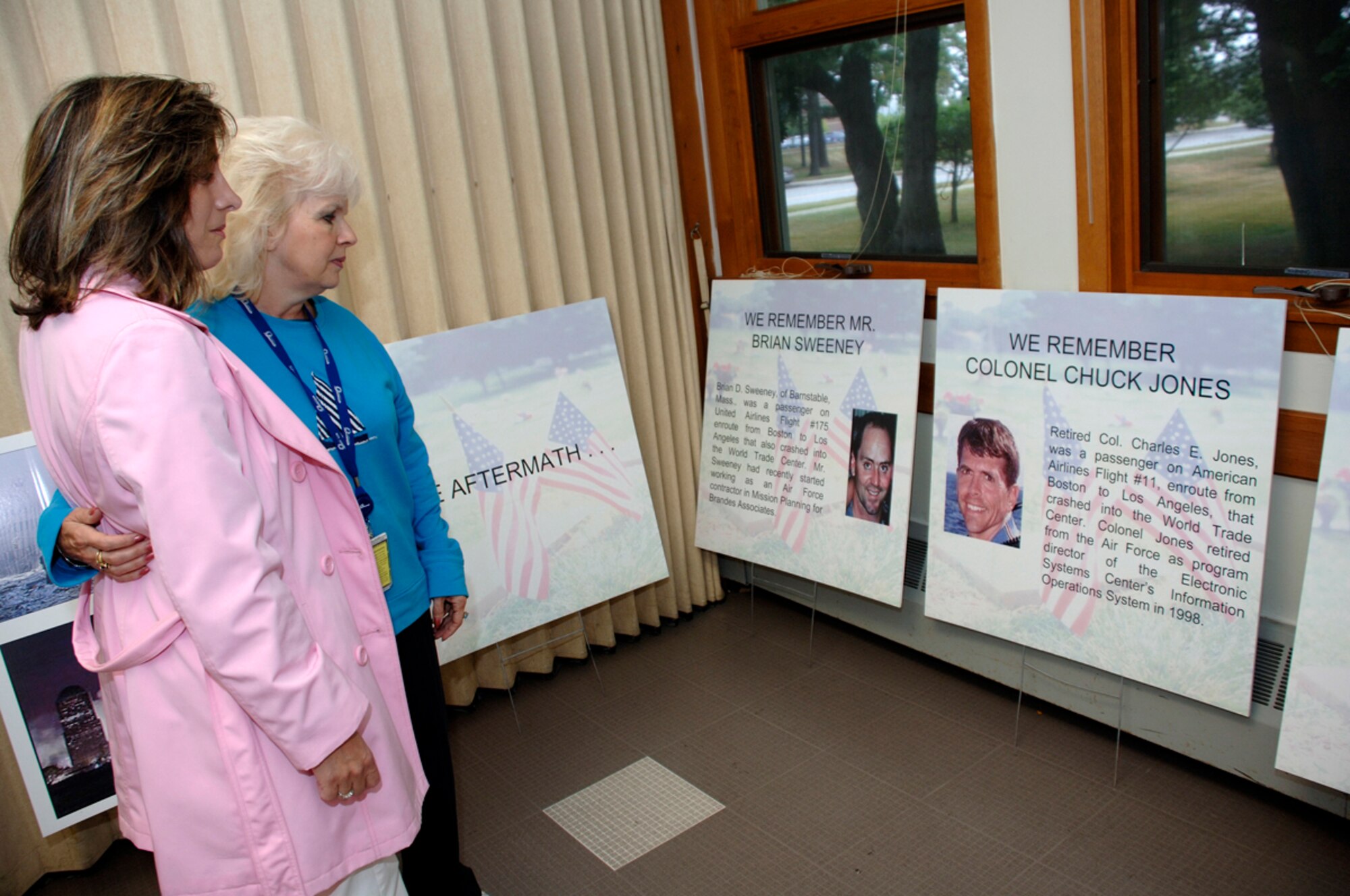 HANSCOM AFB, Mass. -- During the 9/11 Remembrance event held at the Base Chapel, Linda Ben-Ezra, left, 653rd Electronic Systems Group, and Mary Lou Klonoski, 751 ELSG, reflect on the lives of Brian Sweeney and Retired Col. Charles Jones, who died during the 9/11 attacks. Both Mr. Sweeney and Col. Jones were retired Air Force personnel with ties to the Hanscom community. During the event, a bell rang at various times throughout the day in honor of those who lost their lives on Sept. 11, 2001. (U.S. Air Force photo by Jan Abate)