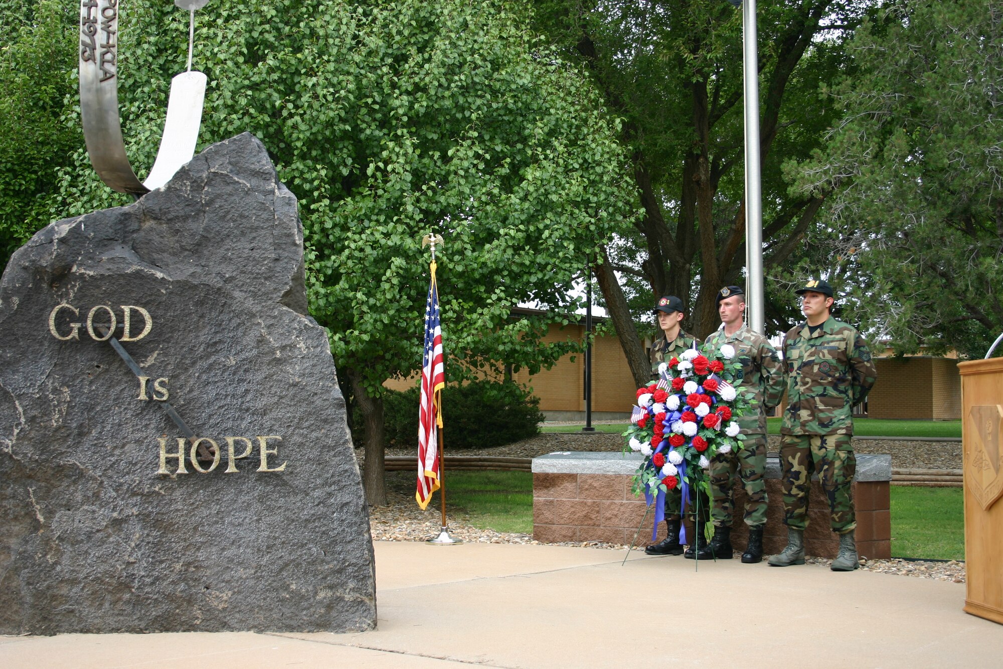 From left to right: Airman Decateur Blair, 27th Civil Engineering Squadron, Senior Airman Mark Maddon, 27th Security Forces Squadron, and Staff Sgt. Roberto Chavez, 27th Aeromedical Dental Squadron, stand behind a memorial wreath during a memorial ceremony to the victims of 9/11.  The ceremony was held at the memorial park behind the base chapel Tuesday morning.(U.S. Air Force photo by Airman Elliott Sprehe)