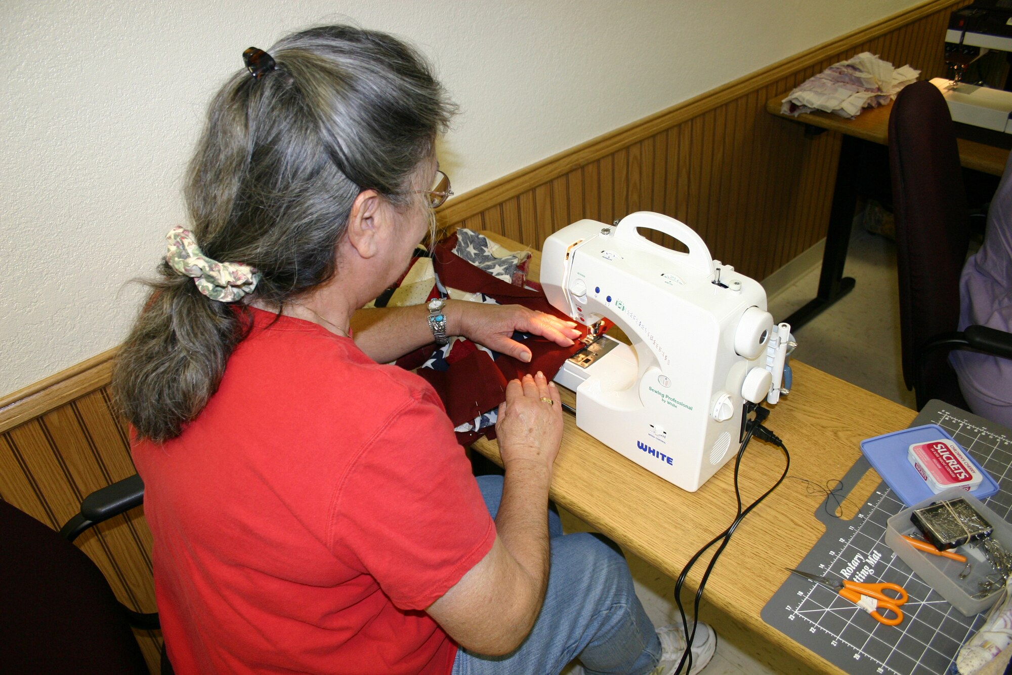 Adelaide Huff stitches together cloth during a meeting of Operation Homefront Quilts. The national group makes quilts for family members of deceased servicemembers. (U.S. Air Force photo by Airman Elliott Sprehe)