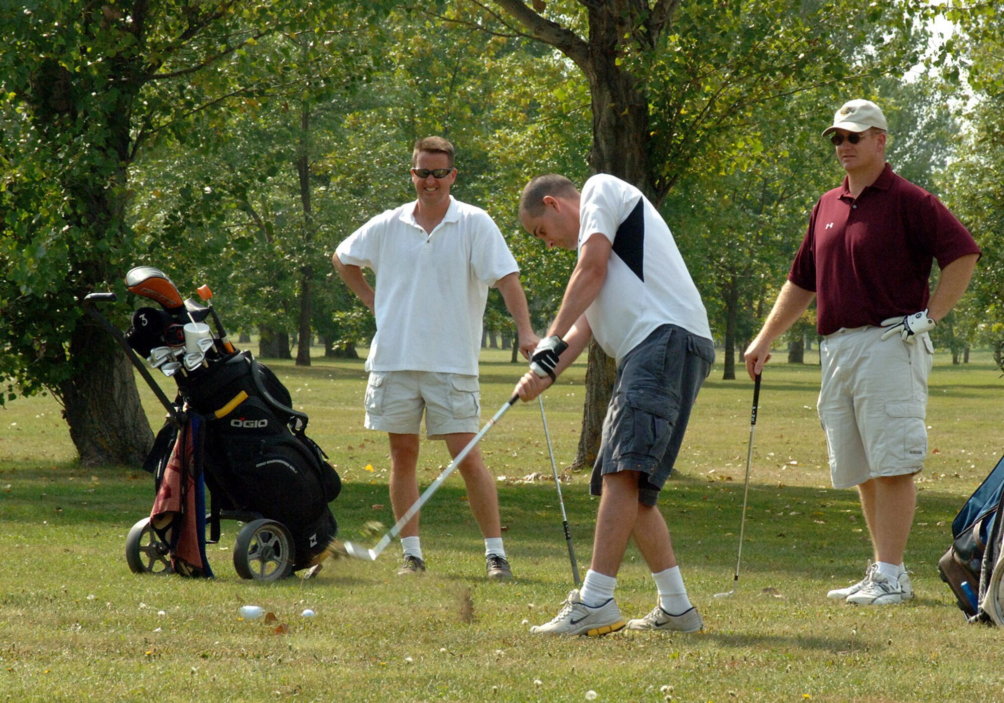 Senior Master Sgt. Larry Cerncky, 319th Communications Squadron, and Master Sgt. Rich Ewers, 319th CS, watch on as Staff Sgt. Joey Lionbarger, 319th CS, drives the golf ball down range as participants in the Top 3 Golf Tournament in support of Airmen Against Drunk Driving (AADD) at Grand Forks AFB, N.D., Sept. 05, 2007 (U.S. Air Force photo/Senior Airman Ser Mae Lampkin)