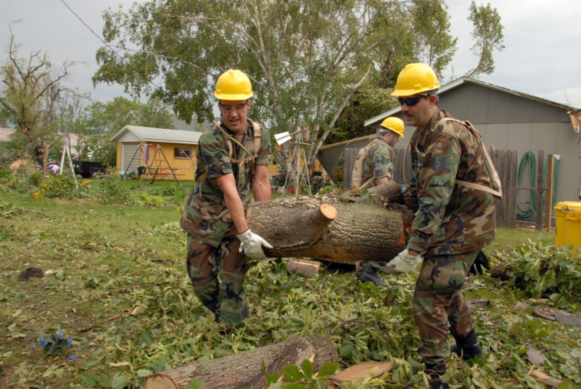 Senior Airman Brandon W. Miller, Dowdon, N.D., left, and Tech. Sgt. Richard M. Hayes, Dilworth, Minn., both of the 119th Wing, remove fallen tree branches and debris from yards in order to clear a path for power line workers in Northwood, N.D. Aug. 28.  The fallen trees are a result of an F4 category tornado on the Fujita scale for rating tornado intensity that hit Northwood, N.D. in the early evening hours of Sunday, Aug. 26. (U.S. Air Force photo/Senior Master Sgt. David Lipp)