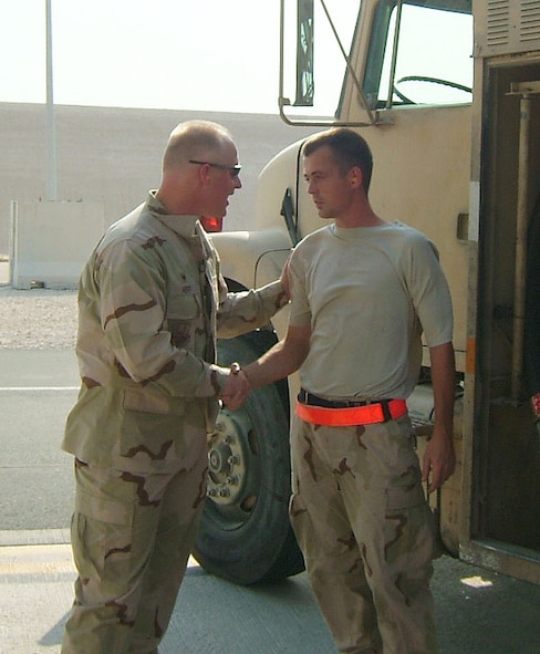 Senior Airman Justin Neal, deployed from the 35th Logistics Readiness Squadron, is is presented with a coin for excellence from Lt. Col. Robert Hoff, 379th Expeditionary Logistics Readiness Squadron commander. Airman Neal recieved the coin for breaking the record for most fuel pumped in one month at his deployed location in Southwest Asia. He pumped 2.1 million gallons of fuel. In recognition of his efforts, a 2.1 million gallon fuel tank was named "Tank Neal."  