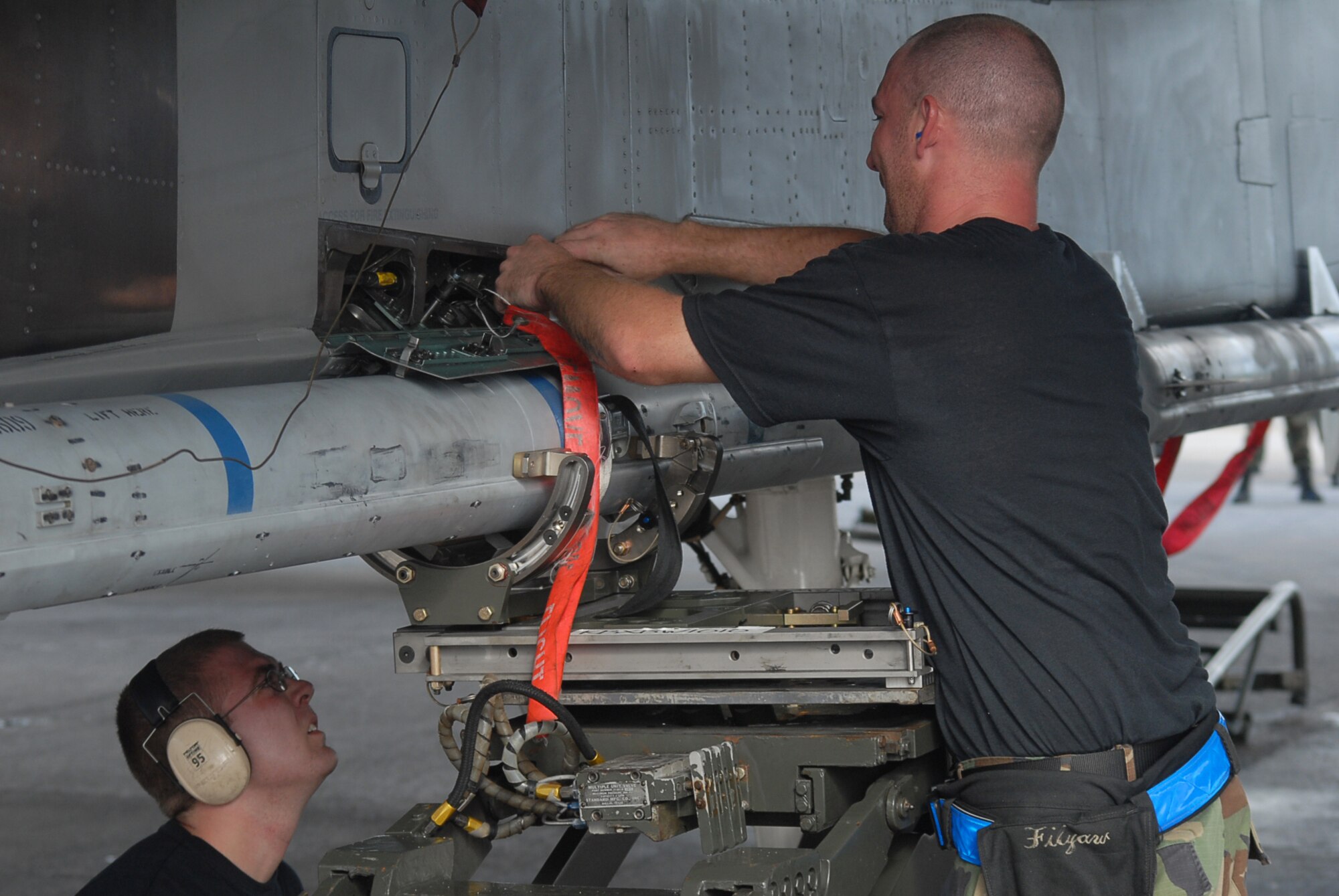 Airman 1st Class Josh Kulaszemicz watches as Staff Sgt. William Filyaw secures a connection on an air-to-air missile on a F-15C during the weapons loading competition at Kadena Air Base, Japan, Sept. 12, 2007. This tests the team's ability of loading F-15s in a fast and safe manner. This competition was held between the 44th and 67th aircraft maintenance units of the 18th Maintenance Squadron. Both Airmen are a weapons load crew members with the 44th AMU. (U.S. Air Force Photo/Senior Airman Darnell T. Cannady)