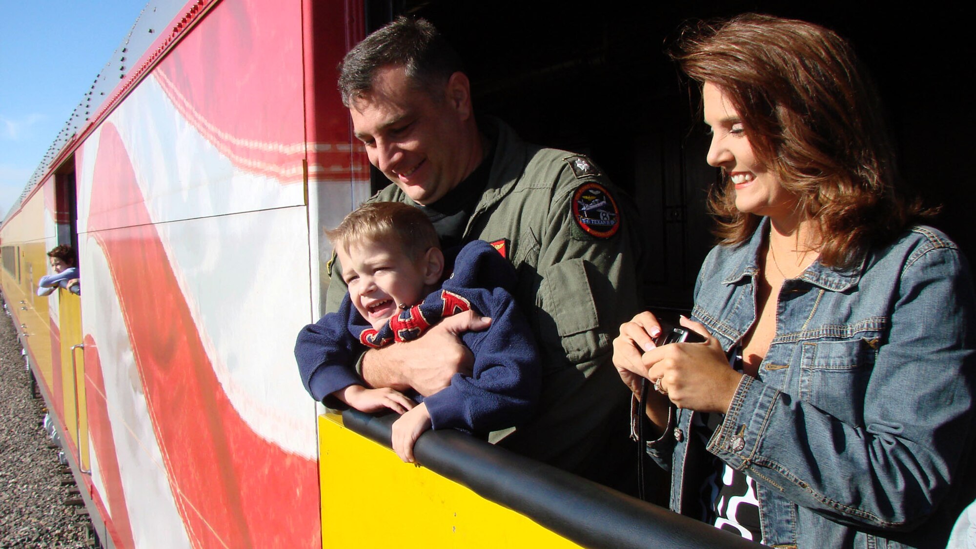 CDR Roger Curry, 8th Flying Training Squadron director of operations, with son Robert and wife Heather,  enjoy the view from the Union Pacific "Oklahoma Centennial Sooner Rocket"  during Tuesday's trip in celebration of the Oklahoma Centennial and in remembrance of Sept. 11, 2001.  More than 80 Team Vance members joined other military and family members from Tinker AFB and Ft. Sill for the historic ride with scheduled stops in Kingfisher and El Reno, where town officials and community members turned out to welcome the train and its special passengers.  Steam Engine 844 was the last of the steam locomotives built for the Union Pacific Railroad in 1944 and weighs more than 1,000,000 pounds.  It was the first time in more than 50 years that a steam engine operated on the Rock Island railroad tracks. (US Air Force photo/Bob Farrell)

