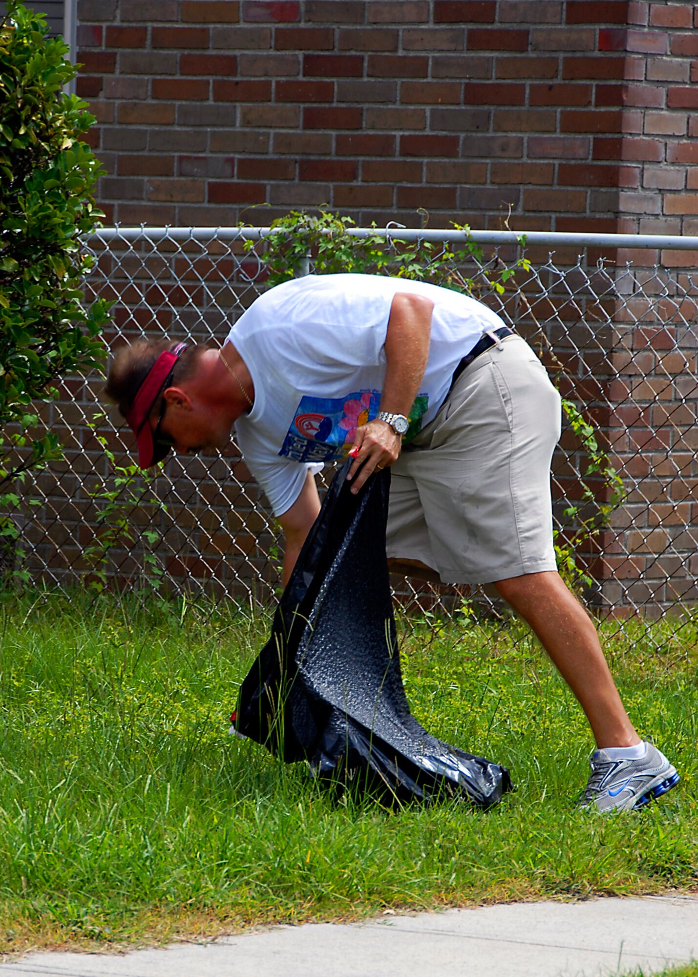 Technical Sergeant Sid Hursey, 315th Airlift Wing, Charleston AFB S.C., helps clean a lawn during the United Way's Day of Caring 2007. (photo by Capt. Chett Collier, USAFR)