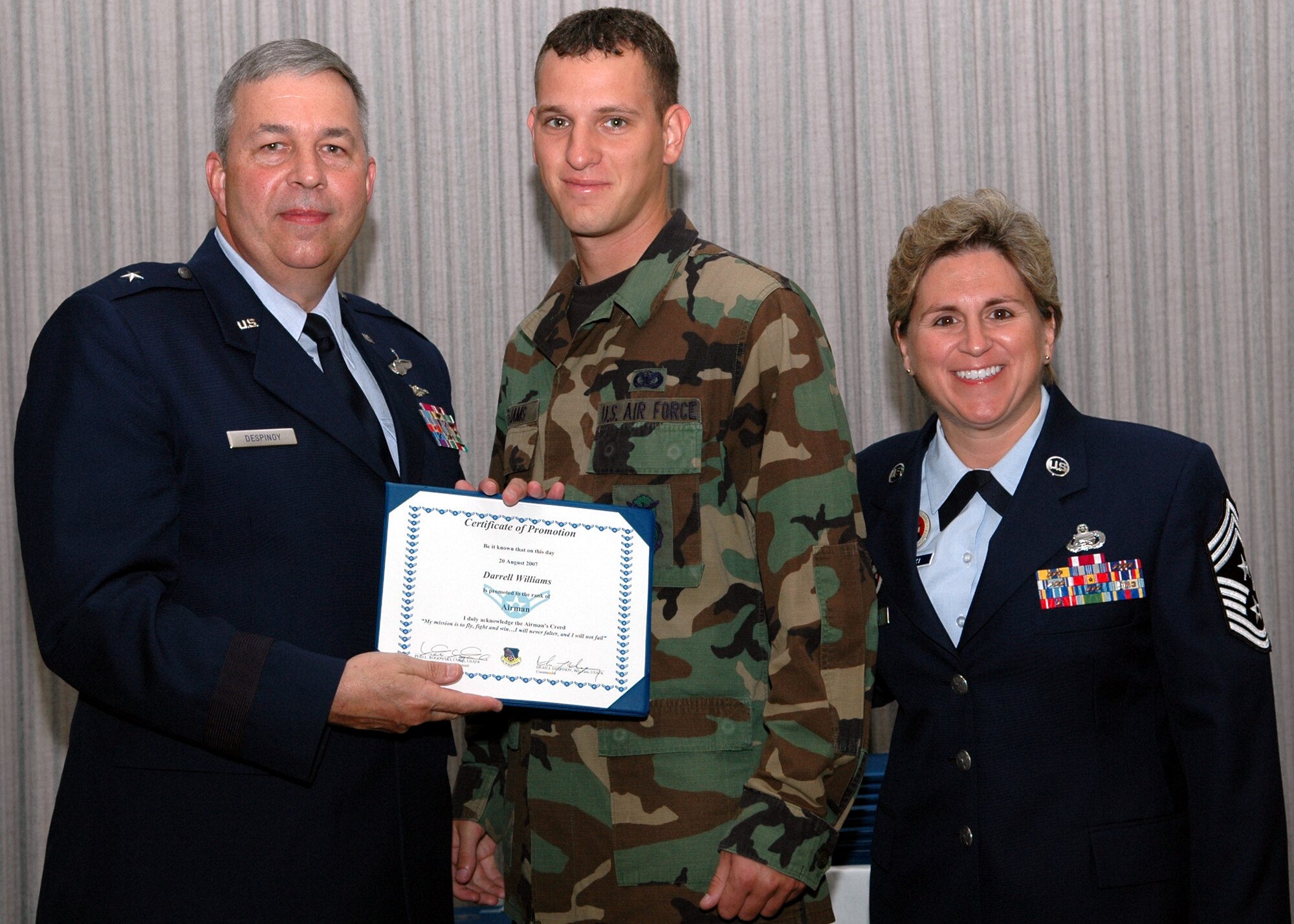 GRISSOM AIR RESERVE BASE, Ind., -- Brig. Gen. Dean Despinoy, left, 434th Air Refueling Wing commander, presents Airman Darrell Williams, 434th Security Forces Squadron, his first stripe. The presentation was made during a special promotion ceremony held at Grissom ARB. Next to Airman Williams is Chief Master Sgt. Peri Rogowski, command chief. (U.S. Air Force photo/SrA Chris Bolen)