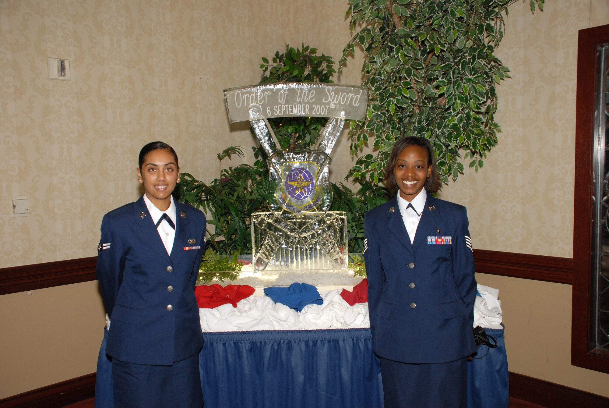 Airman 1st Class Candice Ramtahal, 3rd Airlift Squadron, and Staff Sgt. Marsha Moore, 436th Medical Operations Squadron, pause in front of the Order of the Sword ceremonial ice sculpture Sept. 6. (U.S. Air Force photo/Tech. Sgt. Kevin Wallace)