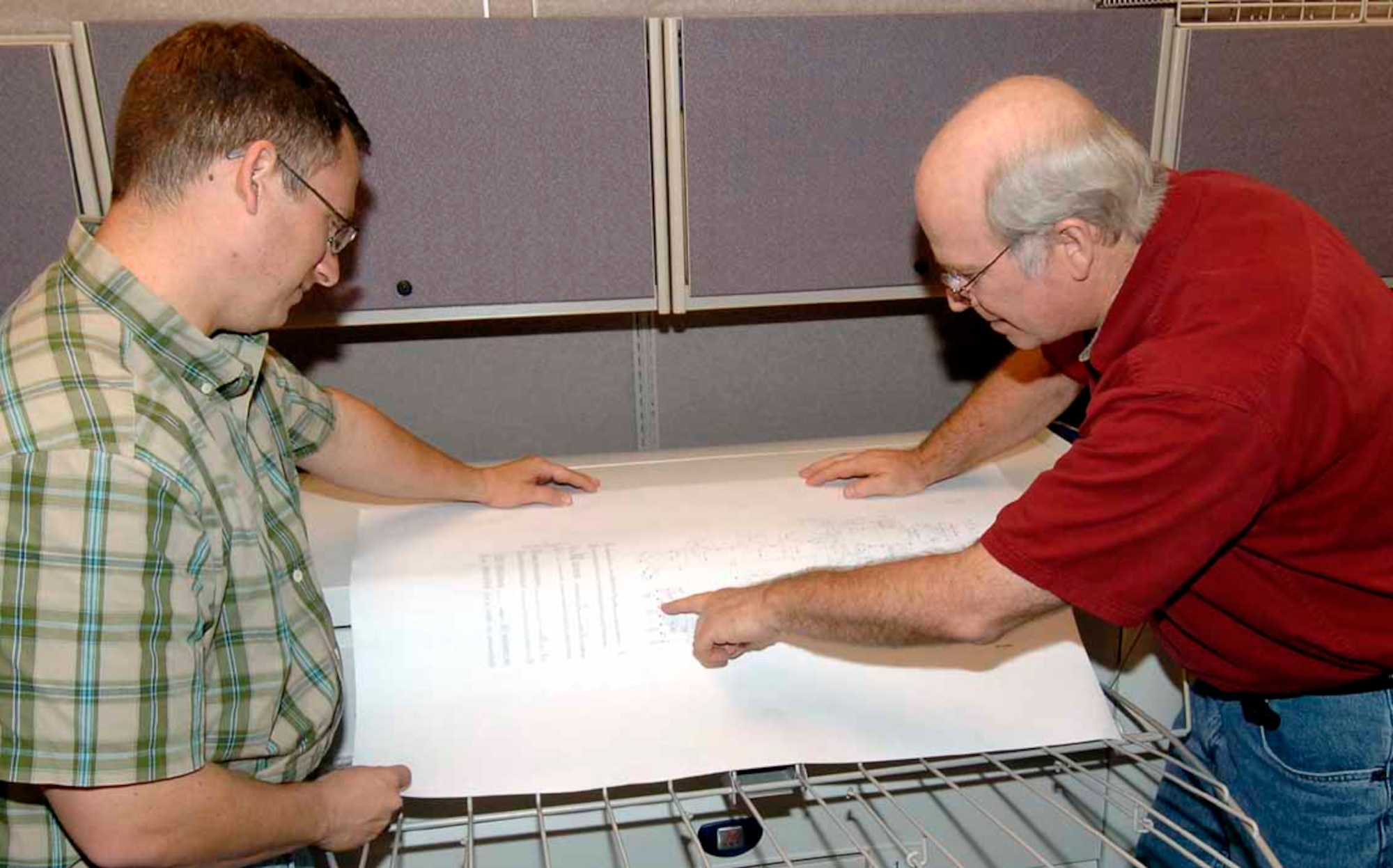 Scott Maxwell, a TO system support representative, and Ron Edmondson, a TO illustrator review a TO printout and proof an illustration. (Air Force photo by Kirk McPheeters)