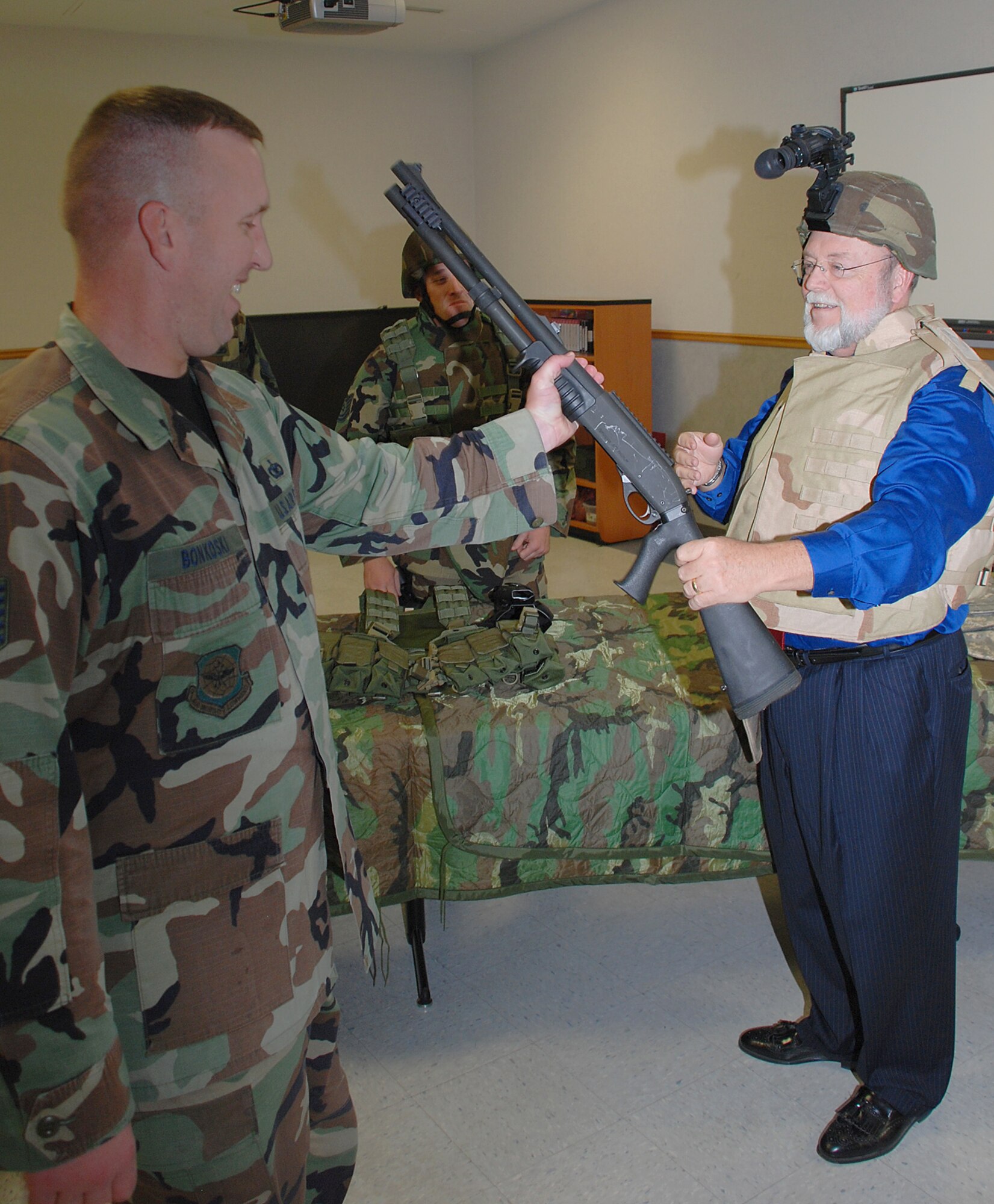 MCCONNELL AIR FORCE BASE, Kan. -- Staff Sgt. Aaron Skapik, 22nd Security Forces Squadron hands a weapon to Gary Rebenstorf, honorary commander for the 931st Air Refueling Group during an honorary commander tour Sept. 11. The event was an orientation of the 22nd Mission Support Group to see how it provides quality-of-life and installation support for the entire McConnell community. (Photo by Airman 1st Class Jessica Lockoski)