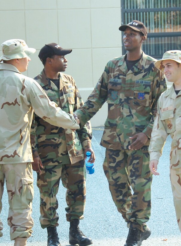 Airman 1st Class Sean Dougherty, left, and Staff Sgt. Matthew Rullo, far right, bid farewell to Staff Sgt. Zuri Brown and  Senior Airman Jamarlon Ellis, center, prior to going on deployment. (US Air Force/Bobby Jones)