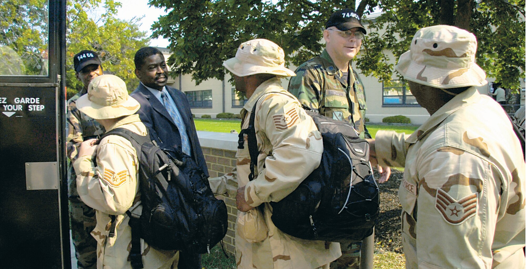 Chief Master Sgt. Karen D. Dupree, left, 844th Communications Group, chief of knowledge management,  Mr. Joseph W. Harrell, center, 744th Communications Squadron director of operations and Lt. Col. Herbert H. Wesselman, 744th Communications Squadron commander bid farewell to Airmen as they board a bus Sept. 7. The Airmen will be deployed to Southwest Asia in support of Operation Enduring Freedom and Operation Iraqi Freedom for four months. (US Air Force/Bobby Jones)