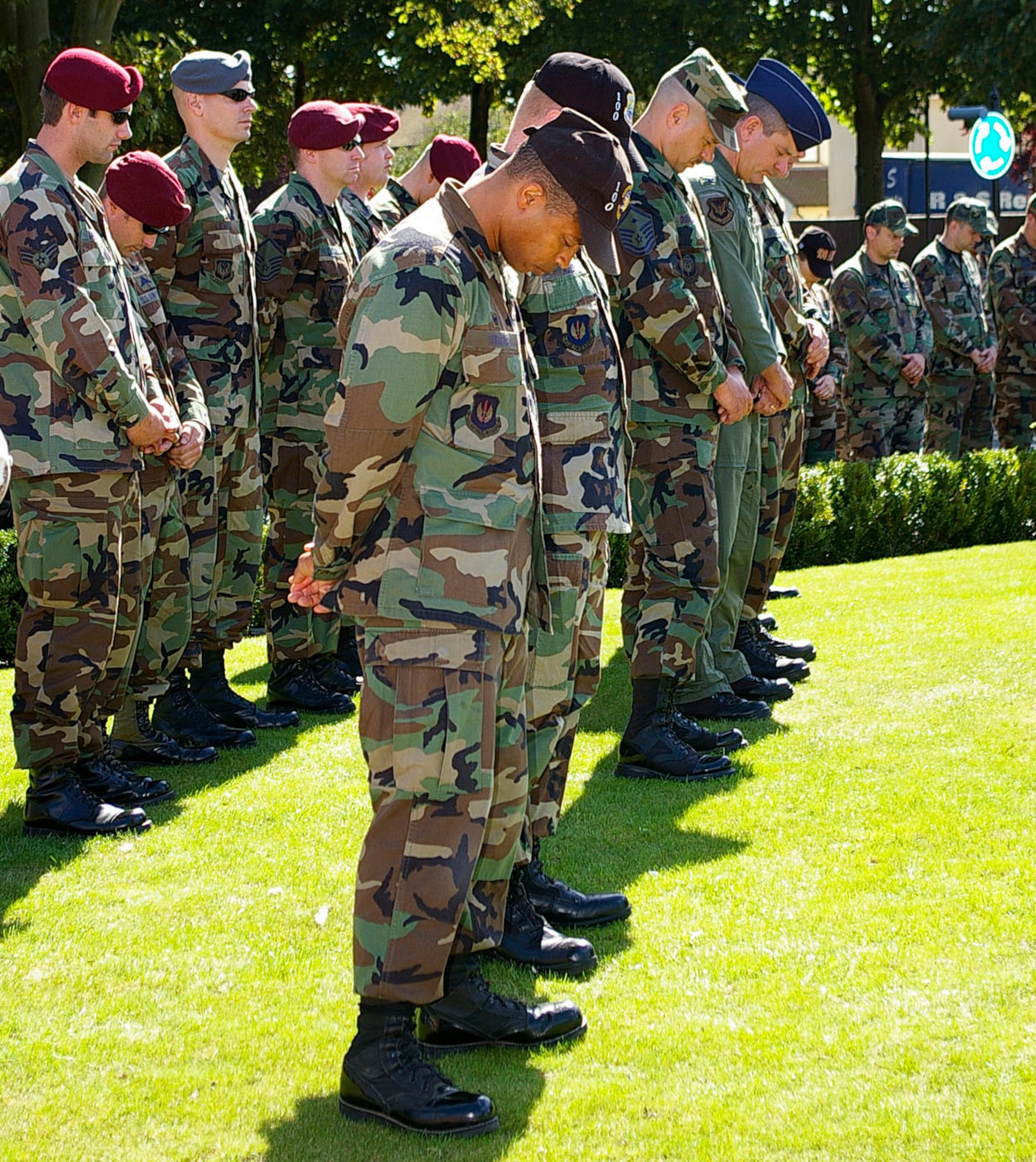 Team Mildenhall members bow their heads during a prayer at the memorial ceremony Sept. 11 at Remembrance Park near the Bob Hope Community Center. (U.S. Air Force photo by Karen Abeyasekere)