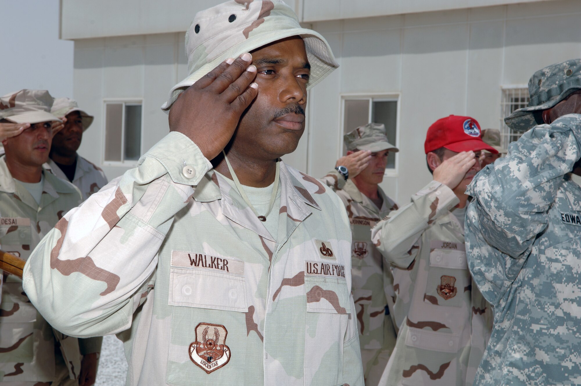 Chief Master Sergeant Bruce Walker salutes during the singing of the National Anthem at a 9-11 memorial service.  Chief Walker was participating in a joint coalition forces formation at the 379th Air Expeditionary Wing located in Southwest Asia on September 11, 2007.  (U.S. Air Force Photo/MSgt Ken Stephens)