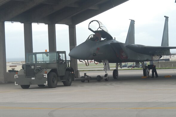 Kadena Airmen tow an F-15C Eagle fighter jet from the flightline into a protective aircraft shelter during preparation for Typhoon Nari on Sept. 14, 2007, at Kadena Air Base, Japan. The base prepared itself for typhoon by moving jets and equipment from the flightline into protective aircraft shelters. The typhoon will hit the island the evening of Sept. 14 with 45 knot winds gusting to 65 knots.  (U.S. Air Force photo/Senior Airman Darnell T. Cannady)