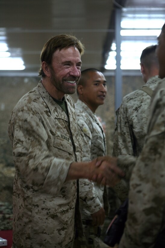 AL ASAD, Iraq - Chuck Norris, actor and martial arts star, shakes the hands of Marines after posing for a photo with them at a meet and greet at the Al Asad Morale, Welfare, and Recreation Center, Sept. 15. Norris made it a point to shake the hand of every service member he met.