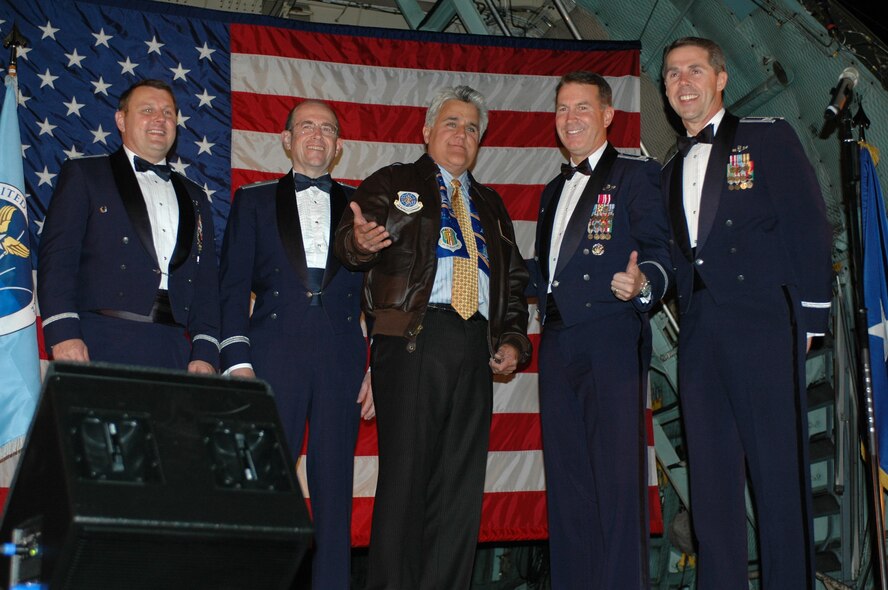 Jay Leno host of The Tonight Show, reacts to the crowd after being presented with his leather flight jacket during the celebration of the Air Force 60th Anniversary Ball Sept. 14 at Travis Air Force Base. On stage with Mr. Leno are [left to right] Col. James Pavlisin, 15th Expeditionary Mobility Task Force vice commander, Brig. Gen. Thomas Gisler, 349th AMW commander, Col. Steve Arquiette, 60th Air Mobility Wing commander and Col. Richard McClain, 615th Contingency Response Wing vice commander (U.S. Air Force photo/Tech. Sgt. Donald Osborn)