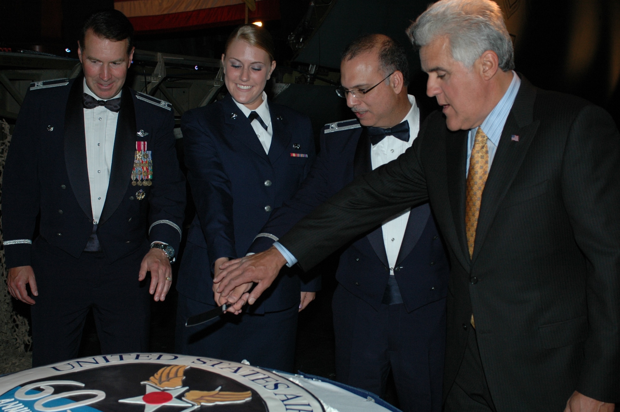 [left to right] Col. Steve Arquiette, 60th Air Mobility Wing commander, Airman Morgan Campbell, 60th Logistics Readiness Squadron, Col. Robert Lucania, 60th Medical Surgical Operations Squadron  and Mr. Jay Leno, host of The Tonight Show, cut the Air Force 60th Anniversary cake Friday at Travis Air Force Base, Calif. In keeping with tradition, the most senior and the most junior time-in –service member cut the cake symbolizing the cooperation that exist between ranks.
(U.S. Air Force photo/Staff Sgt. Matthew McGovern)
