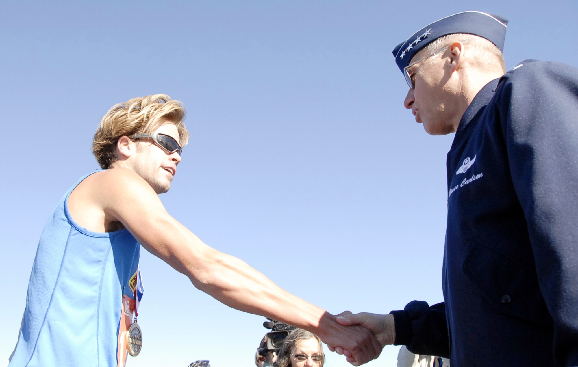 Josh Cox of San Diego gets his medal and a handshake from Gen. Bruce Carlson after winning the mens overall division of the U.S. Air Force Marathon Sept. 15 at Wright-Patterson Air Force Base. Cox's official time of 2:20:57 qualifies him for the U.S. Olympic Team trials to be held in New York City this November. (Christy Webb/U.S. Air Force)