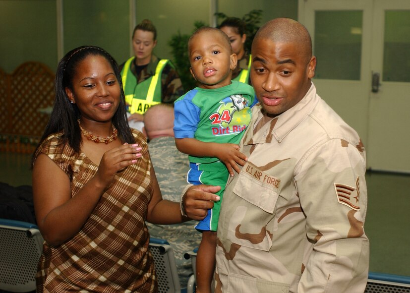YOKOTA AIR BASE, Japan - Staff Sergeant Michael Chase, from the 374th Communications Squadron, Star Chase, his wife, and Markel Chase, his son, speak with family and friends while waiting to leave for his deployment on September 15, 2007.  SSgt Chase is one of approximately 75 Airmen to depart and is part of the second group of Airmen to deploy during the current Air Expeditionary Force rotation. (U.S. Air Force photo by Airman First Class Jonathan Fowler)