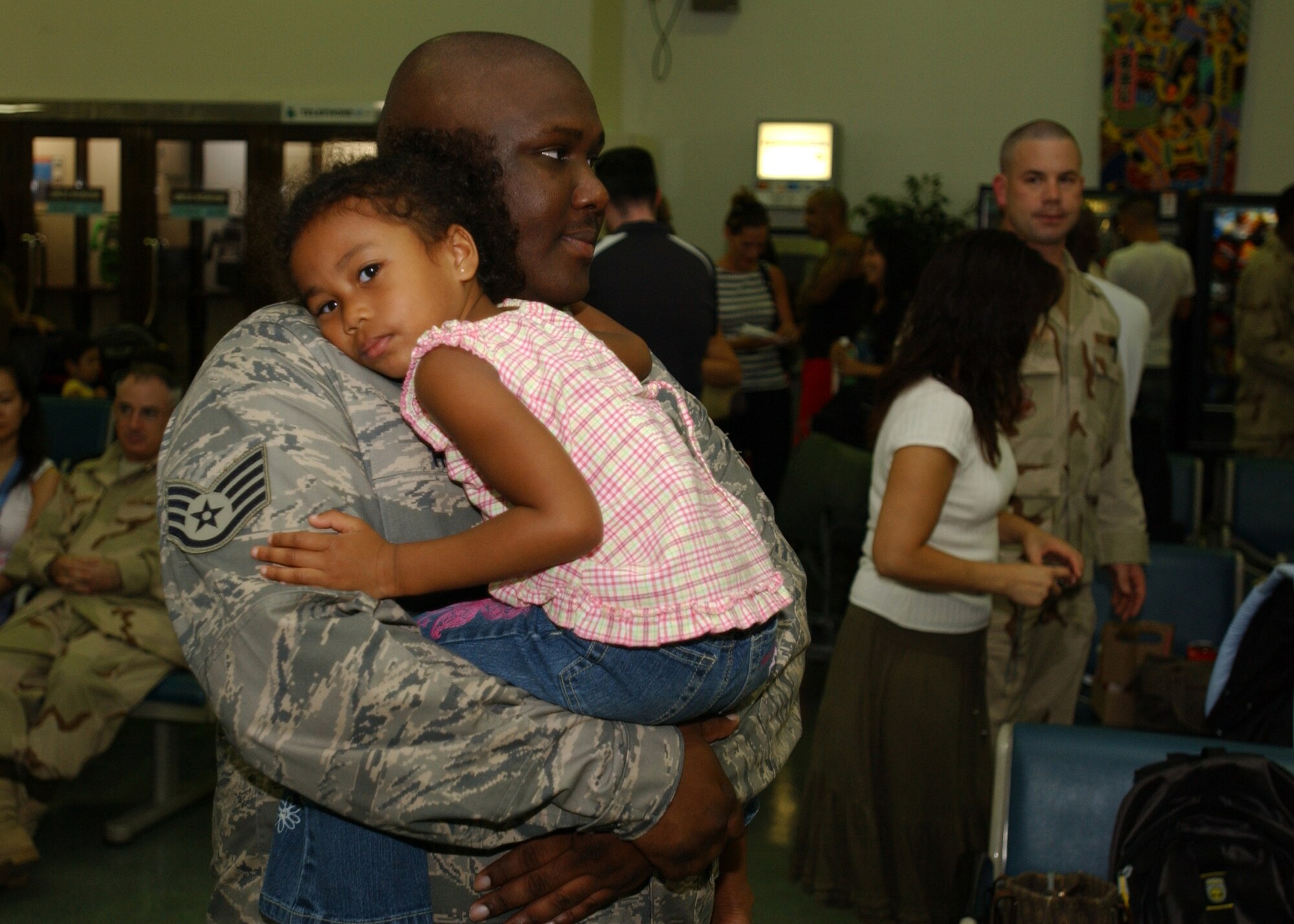YOKOTA AIR BASE, Japan - Staff Sergeant Micheal Thomas, from the 374th Logistics Readiness Squadron, holds his daughter before leaving for his deployment on September 15, 2007.  SSgt Thomasis one of approximately 75 Airmen to depart and is part of the second group of Airmen to deploy during the current Air Expeditionary Force rotation. (U.S. Air Force photo by Airman First Class Jonathan Fowler)