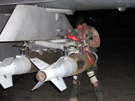 BALAD AIR BASE, Iraq -- Capt. Pete Schnobrich, 13th Expeditionary Fighter Squadron flight commander, preflights his GBU-38 Inertially Aided Munitions for a night sortie and his 100th combat mission in Operation Iraqi Freedom.  Captain Schnobrich previously flew OIF missions as part of the 421st EFS from Hill AFB in 2005. ((U.S. Air Force photo)
