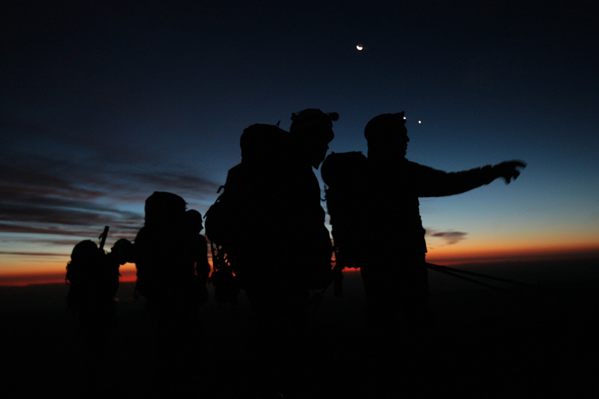Air Force Reserve pararescuemen go over their plan to search the high walls of Mount Hood's Newton-Clark Glacier in the early morning hours of Sept. 8.  A team of six pararescuemen and one SERE (search evasion resistance escape) specialist from the 920th Rescue Wing spent the night at 8,500 feet on Cooper Spur so they could make an early assault to the top of the Glacier.  They set out as part of a large search effort to recover the bodies of two missing climbers presumed killed during a fierce December snowstorm.  The seven Airmen are part of an elite group of men trained to parachute, climb, and scuba dive when necessry to make the most difficult civilian and military rescues.