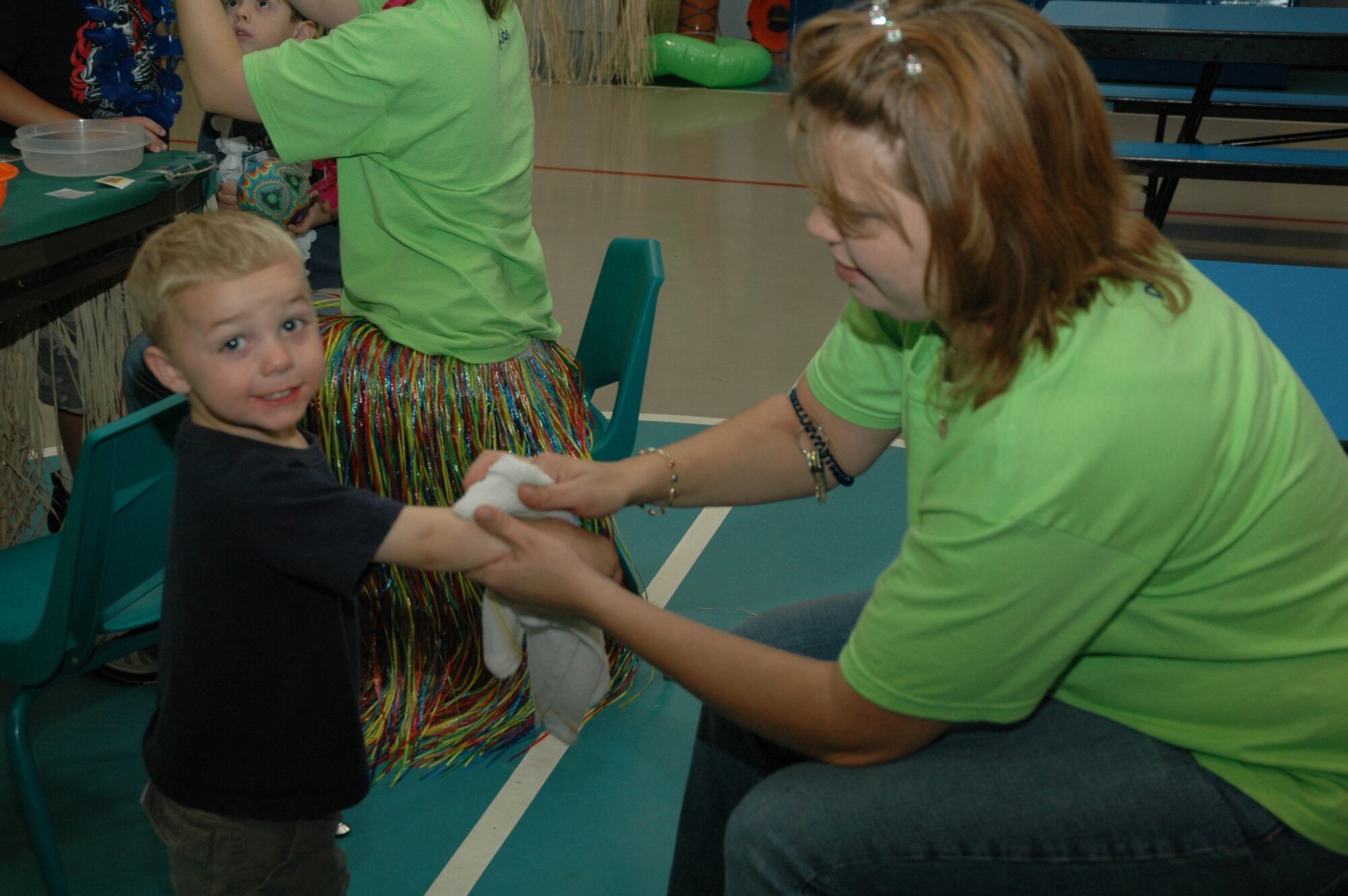 Little Warrior Caleb, 3, smiles as he gets a temporary tattoo at the Youth Programs Center's Children's Luau Sept. 15. The Luau included games, prizes, temporary tattoos and food for the Little Warriors to enjoy. For more information about YPC activities, call 731-4634. (U.S. Air Force photo / Airman 1st Class Emerald Ralston)