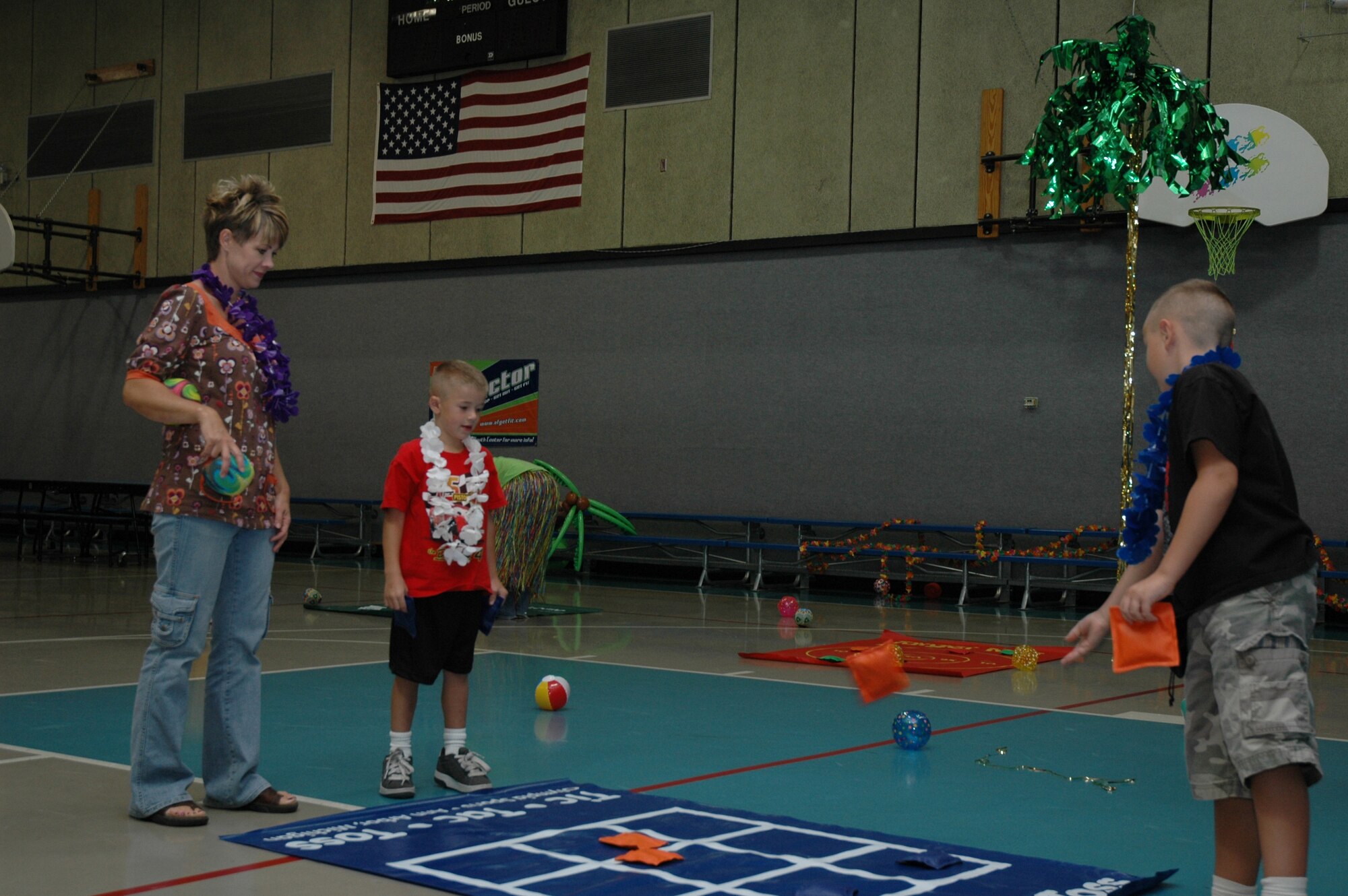 Little Warriors Maverick, 5, and Chase, 7, play tic tac toe with their mom, Debbie, at the Children's Luau held at the Youth Programs Center Sept. 15. For more information about future activities at the YPC, call 731-4634. (U.S. Air Force photo / Airman 1st Class Emerald Ralston)