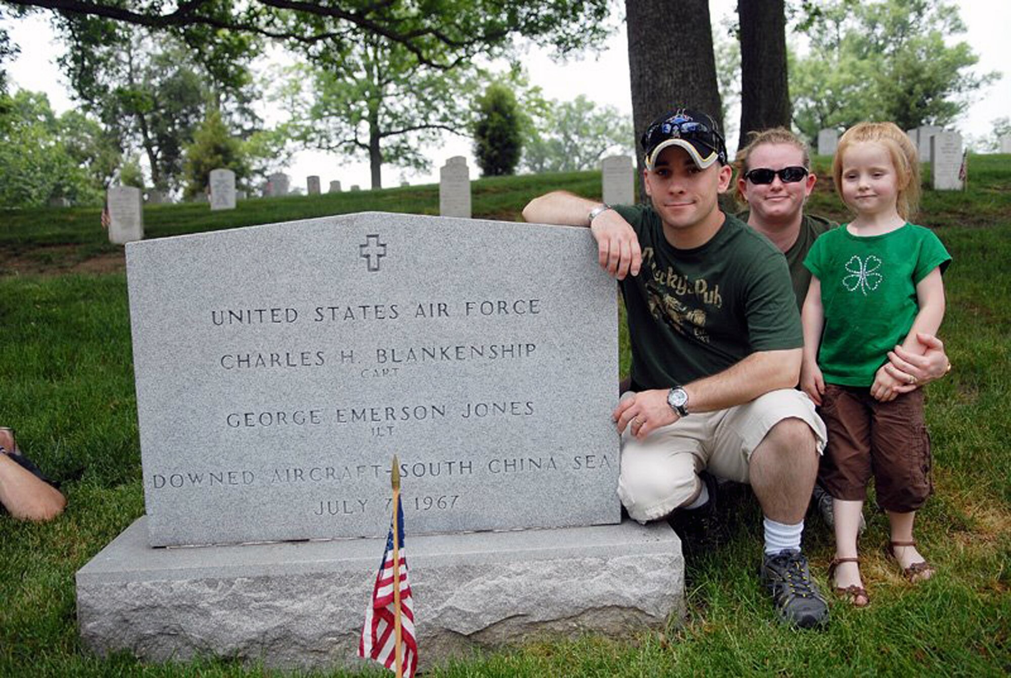 Staff Sgt. Gary Ritter, combat arms instructor for the U.S. Air Force Expeditionary Center at Fort Dix, N.J., along with his wife Kristina and daughter Cheyenne, stop for a photo by the gravesite of former Air Force 1st Lt. George E. Jones of Aberdeen, Miss., at Arlington National Cemetery May 28, 2007. Sergeant Ritter made the journey to Arlington to meet with the family of Lieutenant Jones to give them a POW/MIA bracelet he'd held for 19 years.  He gave the bracelet to the daughter of Lieutenant Jones on Memorial Day 2007.  (Photo by Christopher Duggan)