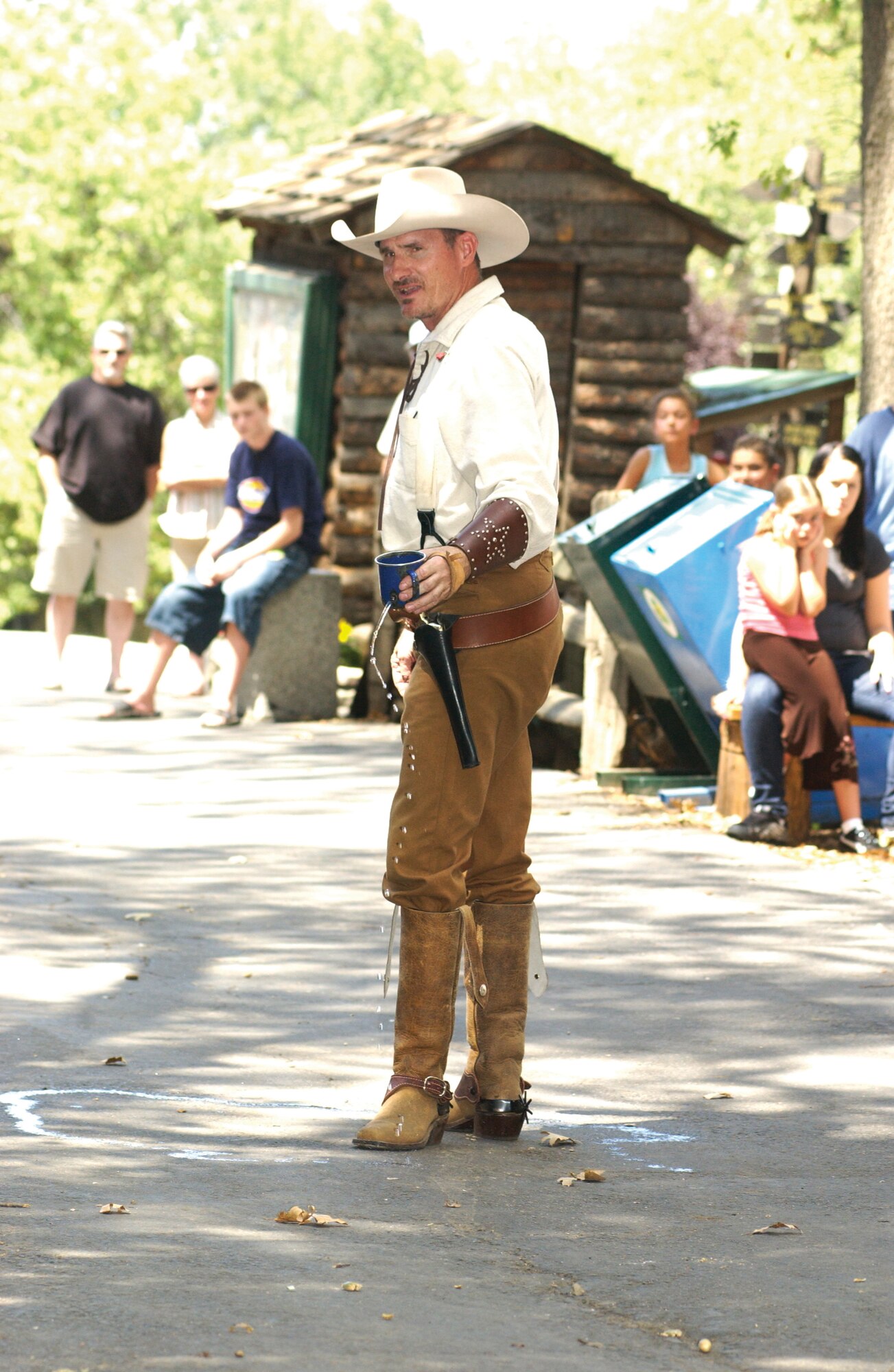 Sergeant Higginson, playing Concho Creek Kid, gets a hole shot in his cup by the town marshal. He is part of a Wild West showdown held regularly at Oak Tree Village in Oak Glen, Calif.  (U.S. Air Force photo by Amy Abbott)