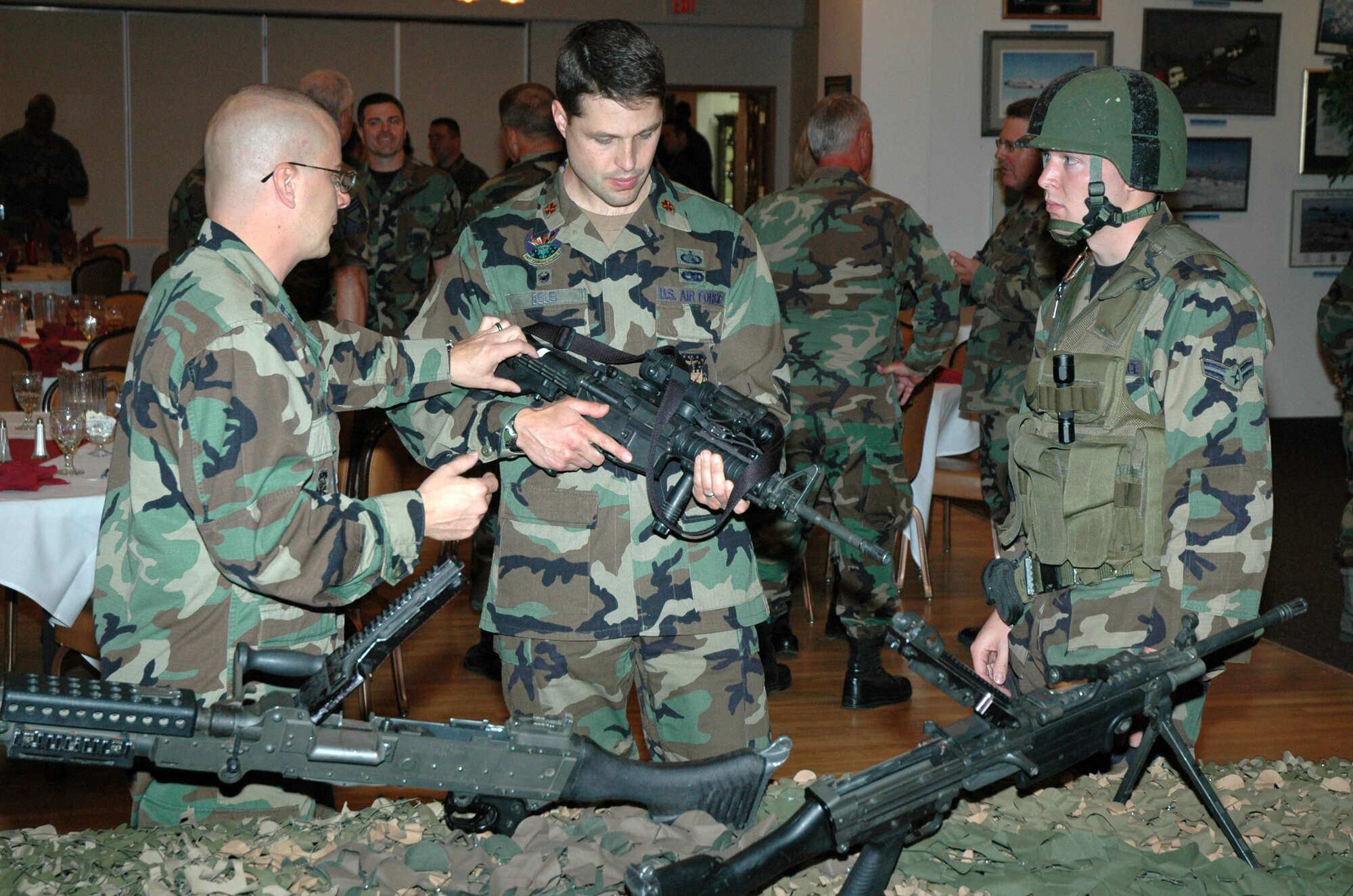 Capt. Ralph Alvord, 341st Security Forces Squadron operations officer, and Airman 1st Class Brandon Uhl, 741st Missile Security Forces Squadron convoy response force member, explain the M-4 carbine to Maj. Bill Belei, 341st Communications Squadron commander, during a luncheon at Malmstrom Air Force Base Sept. 12. The luncheon was held to enhance working relationships and build functional bridges between Malmstrom and Montana Air National Guard leadership. (U.S. Air Force photo/Airman 1st Class Dillon White)

