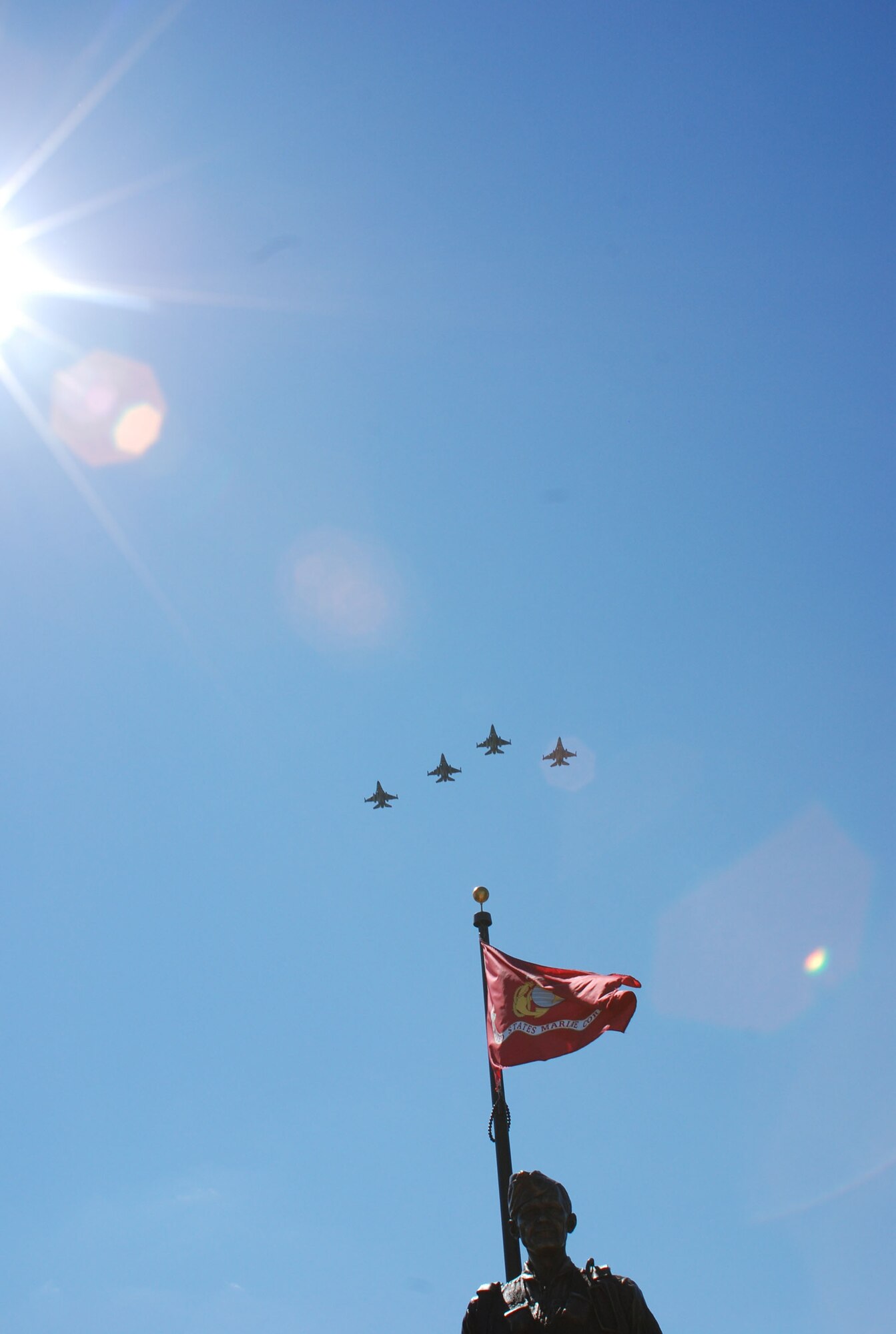 Four F-16s fly over a bronze statue of retired Col. James H. Kasler during a veteran's memorial dedication in Momence, Ill., Sept. 15, 2007. The fighter aircraft are from Air Force Reserve Command's 301st Fighter Wing, Naval Air Station Joint Reserve Base Fort Worth, Carswell Field, Texas. (U.S. Air Force photo/1st Lt. Dustin Doyle)