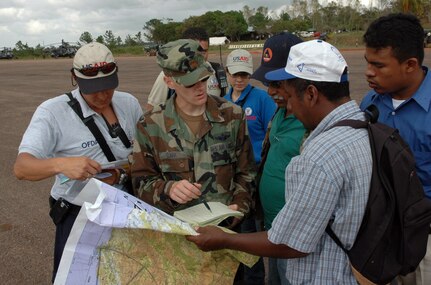 PUERTO CABEZAS, Nicaragua - Locals and U.S. State Department Office of Foreign Disaster Assistance help Air Force Maj. Jason Clark find coordinates for small communities on a map Sept. 16.  Aircrews and UH-60s from Joint Task Force Bravo in Honduras deployed here to distribute U.S. relief materials.  The U.S. State Department and Department of Defense are working together to bring food, water and other needed items to small communities on the Nicaraguan coast that were affected by the hurricane.  (Army photo by Specialist Grant Vaught)