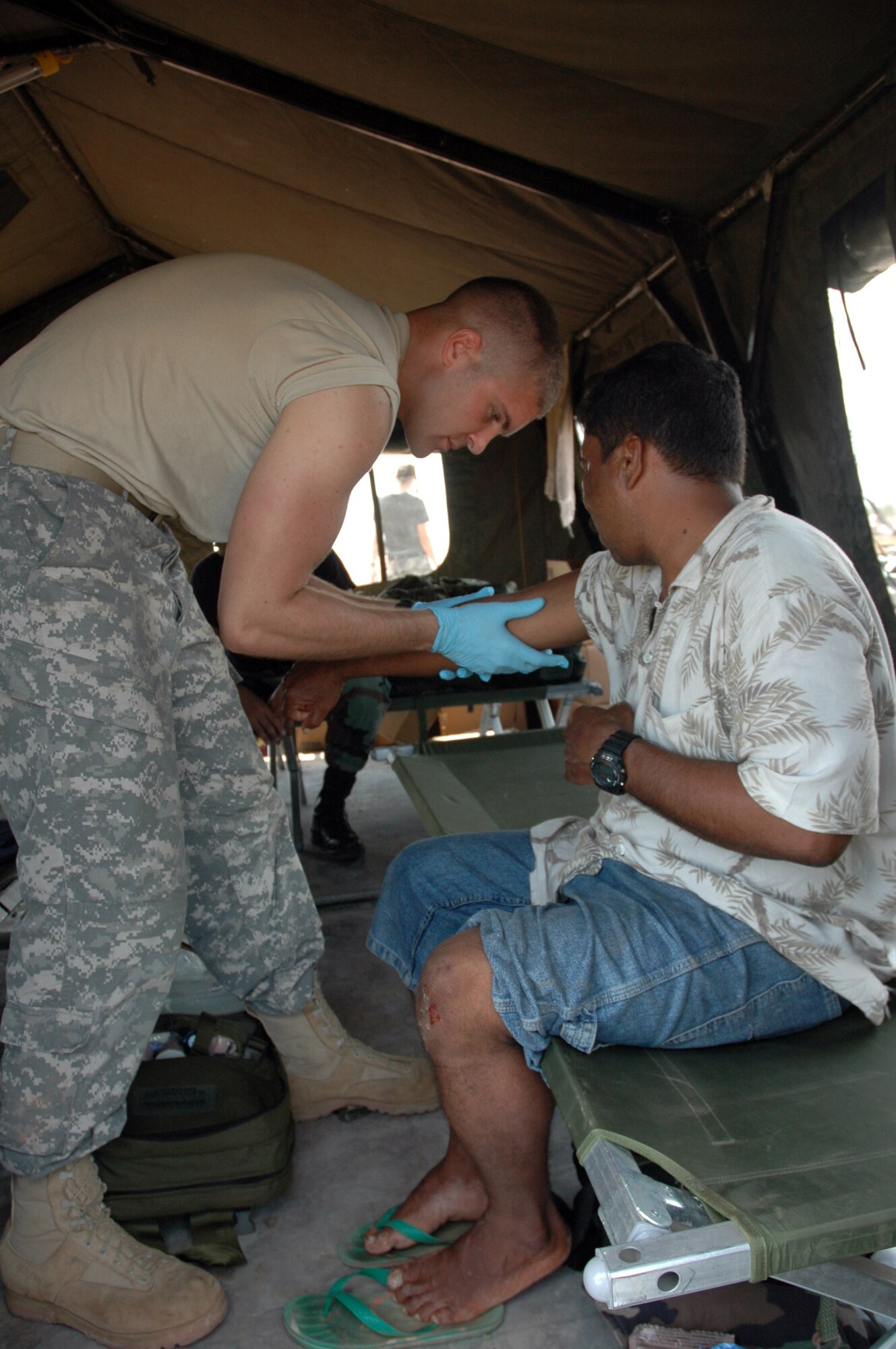 PUERTO CABEZAS, Nicaragua – Army medic Spc. Jonathan Potter provides medical care to a local man who was injured by flying debris on the flightline here Sept. 15.  Specialist Potter is part of a team deployed from Joint Task Force Bravo in Honduras to provide relief in Nicaragua after Hurricane Felix.  The U.S. State Department and Department of Defense are working together to bring food, water and other needed items to small communities on the Nicaraguan coast that were affected by the hurricane.  (Army photo by Specialist Grant Vaught)