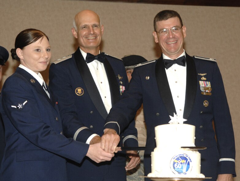 MINOT AIR FORCE BASE, N.D. --(from left) Airman Samantha Reed, 5th Maintenance Operations Squadron, Maj. Gen Roger Burg, 20th Air Force commander, and Col. Glenn Lang,  5th Mission Support Group commander, slice a cake at Minot AFB's 60th Anniversary Air Force Ball. Airman Reed was the youngest Airmen present, and General Burg was the most senior Airman and guest speaker, while Colonel Lang was affectionately dubbed "the most experienced" Airman. The ball included speeches by senior leaders, performances by the base honor guard and living legends, and music by a local jazz band. (U.S. Air Force photo by Senior Airman Christopher Boitz)