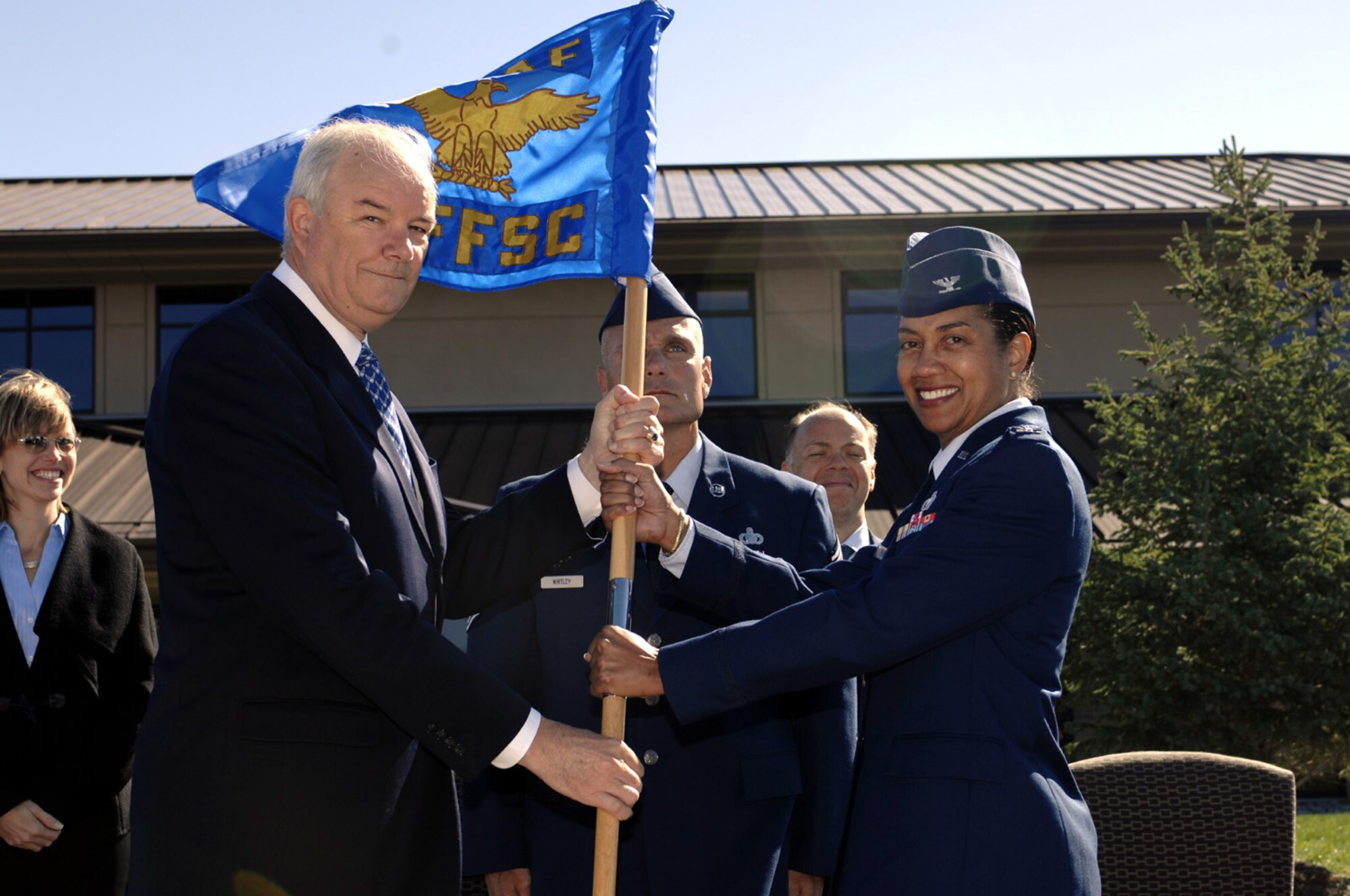 Secretary of the Air Force Michael Wynne hands the Air Force Financial Services Center guidon to Col. Judy Perry, AFFSC commander, during her assumption of command ceremony Sept 14. The center officially opened its door s to customers Sept 14 with grand opening celebrations. Secretary Wynne also took time to visit with various units and base personnel during a tour. (US Air Force photo by Staff Sgt. Mike Keller)