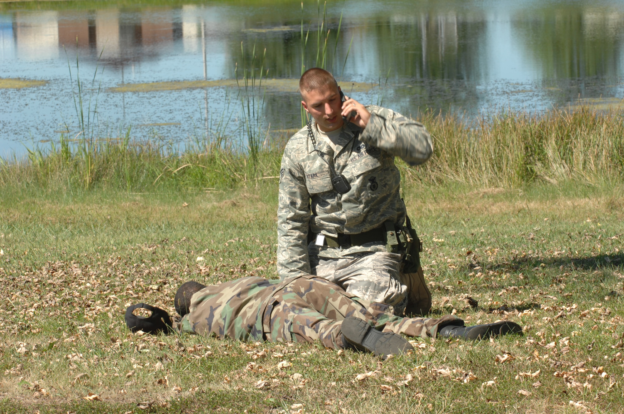 WHITEMAN AIR FORCE BASE, Mo. -- Senior Airman Derin Stark, 509th Security Forces Squadron, checks on Staff Sgt.  Christopher Alexander 509th Operations Support Squadron, at Ike Skelton Park Sept 12. Sergent Alexander was affected by chemicals during the exercise. (U.S. Air Force photo/Airman First Class Cory Todd)