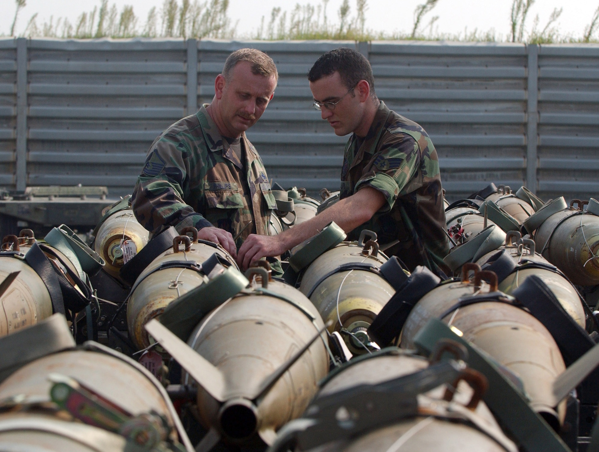 KUNSAN AIR BASE, South Korea -- Master Sgt. Torre Phillips (left), assigned to the 555th Expeditionary Fighter Squadron 'Triple Nickel" from Aviano AB, Italy, inspects an MK-82 bomb with his son Senior Airman David Phillips, 8th Maintenance Squadron Sept. 13. Sergeant Phillips is deployed here for a four-month rotation while his son completes his one-year remote tour here. (U.S. Air Force photo/Senior Airman Steven Doty)                               