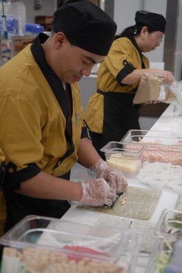 Employees at Andersen's newly opened sushi bar inside the commissary prepare sushi during the grand opening Sept. 13. In the first two days of the sushi bar being open, it generated more sales than any commissary stateside did in a two-day period. (Photo by Airman 1st Class Daniel Owen)