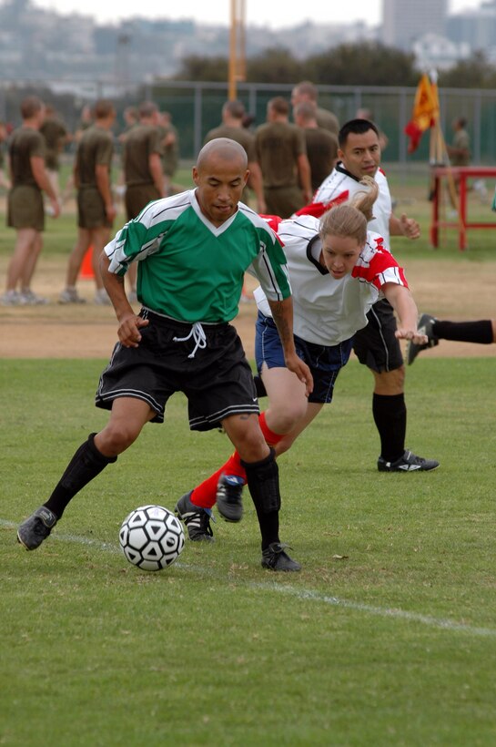 Staff Sgt. Gabriel Jaramillo, Support Bn., guards the ball as members of 12th Marine Corps District attempt to stop him from scoring a goal.
