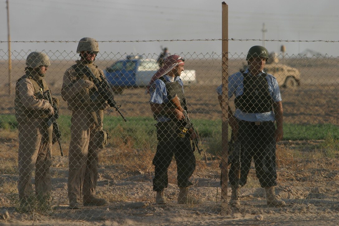 Cpl. Alan J. Bennett (left) and Sgt. Christopher D. McClain with 3rd Platoon, Battery C, 1st Battalion, 12th Marine Regiment (1/12), Task Force Military Police (TFMP) conduct a joint patrol with Iraqi Highway Police on 18 September 2007. The joint patrol is being conducted to build community relations and gain intelligence on local insurgent activity around the Traffic Control Point on ASR Golden. 1/12, TFMP is deployed with Multi National Forces-West in support of Operation Iraqi Freedom in the Al Anbar province of Iraq to develop Iraqi Security Forces, facilitate the development of official rule of law through democratic reforms, and continue the development of a market based economy centered on Iraqi reconstruction. (Official USMC photograph by Cpl. Thomas Lew)