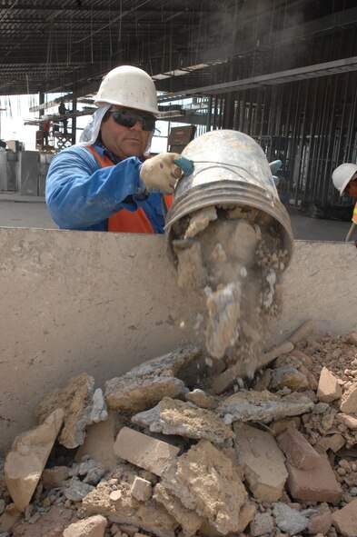 Mr. Gorge Gallegos, member of the safety team from Urban
Association of El Paso, Texas, dumps out debris while here at
the construction site of the New Fire Station on September 11. (U.S. Air Force photo by Senior Airman Anthony Nelson)