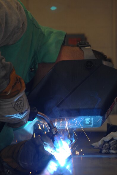 DYESS AIR FORCE BASE, Texas - Senior Airman Troy Wesley, a Metal Technologist, from the 7th Equipment Maintenance Squadron uses a torch to cut down an old metal stand for scrap metal September 18. The Metal Technology shop works on all equipment from mechanics stands to wire welding. (U.S. Air Force photo by Airman 1st Class Jennifer Romig)