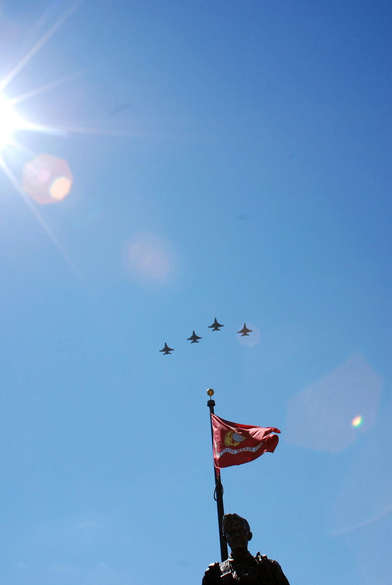 Four F-16 Fighting Falcons fly over a bronze statue of retired Col. James H. Kasler during a Sept. 15 veteran's memorial dedication in Momence, Ill. The fighter aircraft are from Air Force Reserve Command's 301st Fighter Wing at Naval Air Station Joint Reserve Base Fort Worth from Carswell Field, Texas. (U.S. Air Force photo/1st Lt. Dustin Doyle) 
