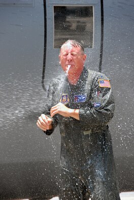 Lt. Col. Doug Lipscombe endures the traditional hose down after his fini flight. Dousing is a ritual of honor bestowed upon aviators who are retiring from service or sometimes moving on to a new job at a different unit. Colonel Lipscombe served with the 53rd Weather Reconnaissance Squadron as an Aerial Reconnaissance Weather Officer and instructor. He retired with   28 years of military service. (U.S. Air Force Photo/Senior Airman Tabitha Spinks)