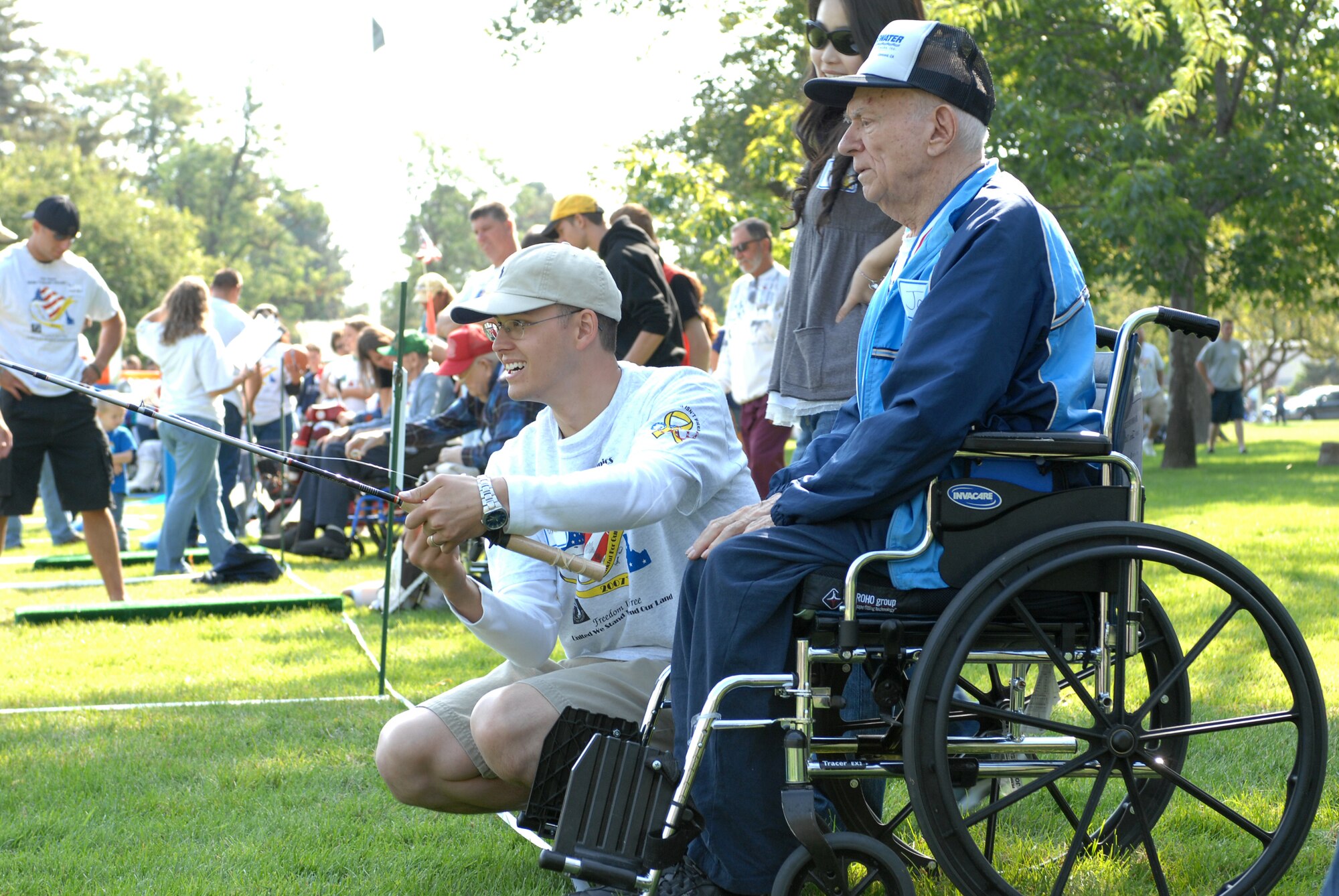 MOUNTAIN HOME AIR FORCE BASE, Idaho -- From left, Senior Airman Elliot Hoffman, 366th Equipment Maintenance Squadron, assists veteran John Olesko in the casting competition during the 20th annual Idaho Veterans Olympics at the Veterans Home in Boise Sept. 15. Hosted by the Idaho State Veterans Home and the Veterans Affairs medical center, this event relied heavily on the willingness and sacrifice of volunteers, said retired Chief Master Sgt. Phil Hawkins, one of the Veterans Olympics coordinators. (U.S. Air Force photo/Airman 1st Class Ryan Crane)