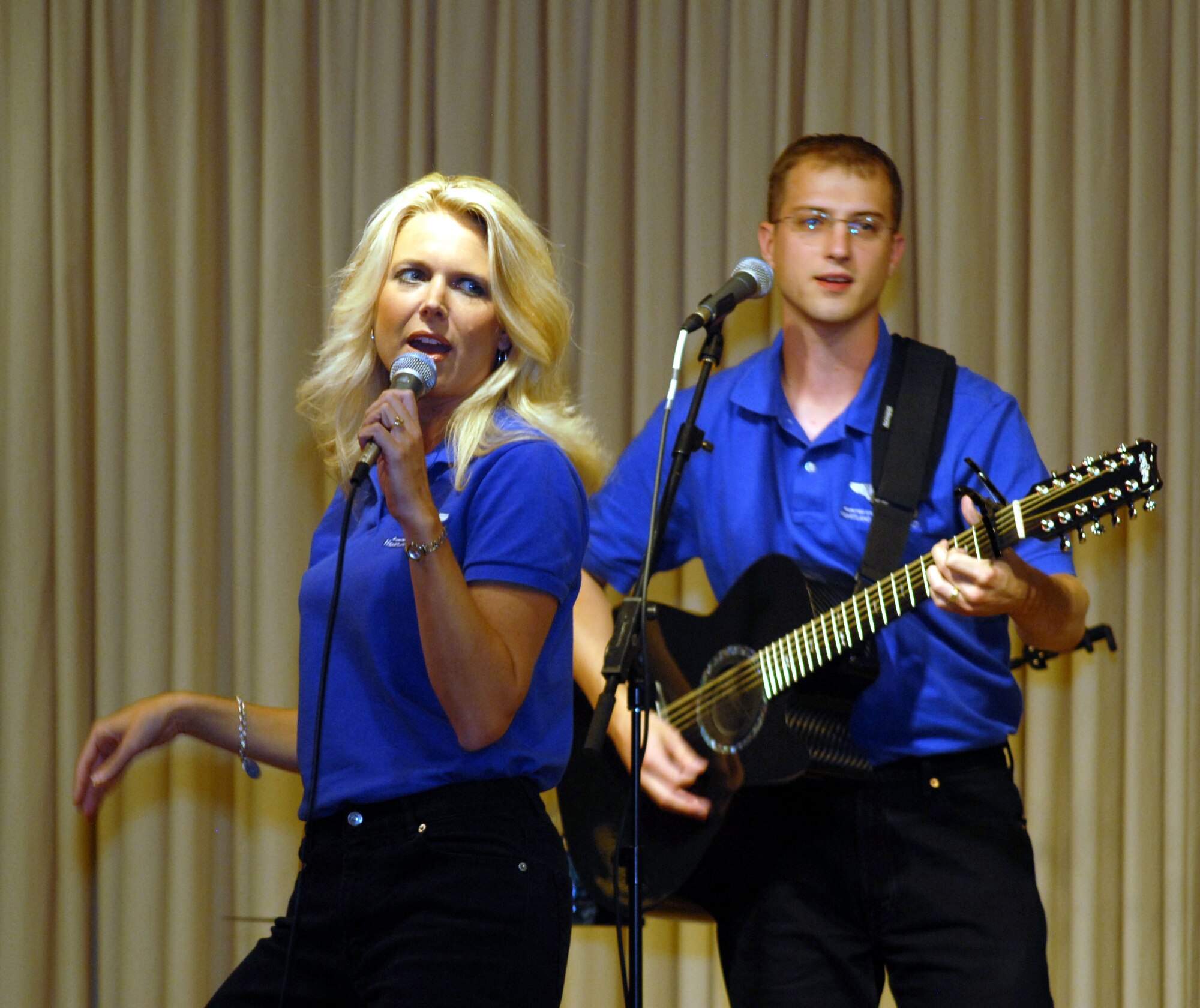 Night Wing, the country/rock showcase group of the United Statess Heartland of America Band, was the featured entertainment at the Salute to the Community Dinner at Malmstrom Air Force Base, Mont., Sept. 14. Two members of the six-person group, Tech. Sgt. Lara Murdzia and Staff Sgt. Danial Bragdon, perform here. (U.S. Air Force photo/John Turner)